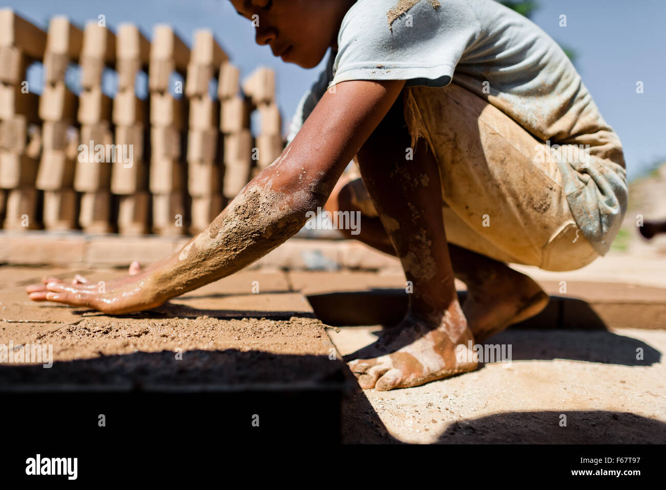 Moisés, une à l'âge de 13 ans, garçon salvadorienne, remplit un moule avec de l'argile pour la fabrication de briques à une briqueterie dans Istahua, El Salvador. Banque D'Images