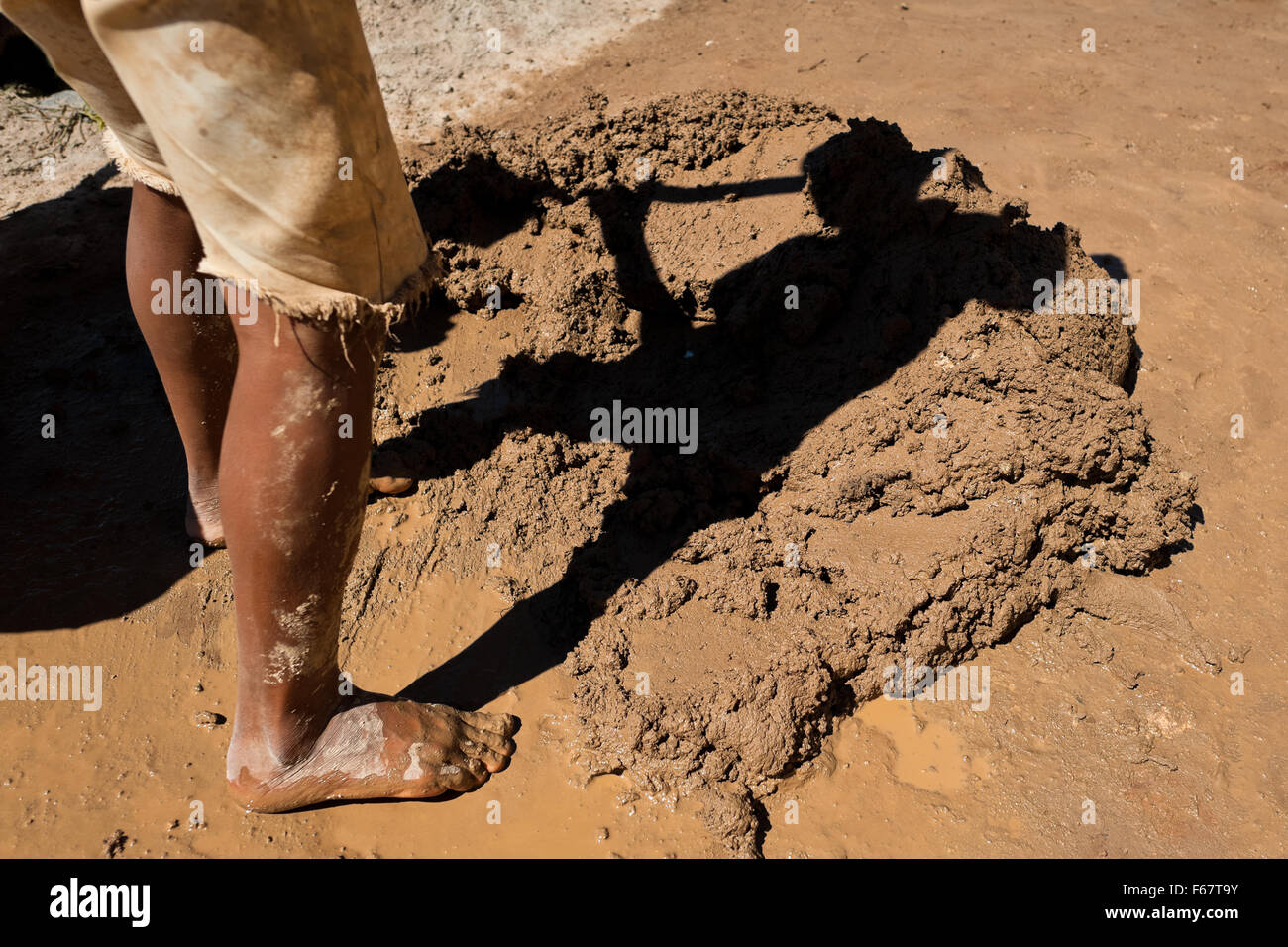 Moisés, une à l'âge de 13 ans, garçon salvadorienne, pelles de l'argile humide à une briqueterie dans Istahua, El Salvador. Banque D'Images