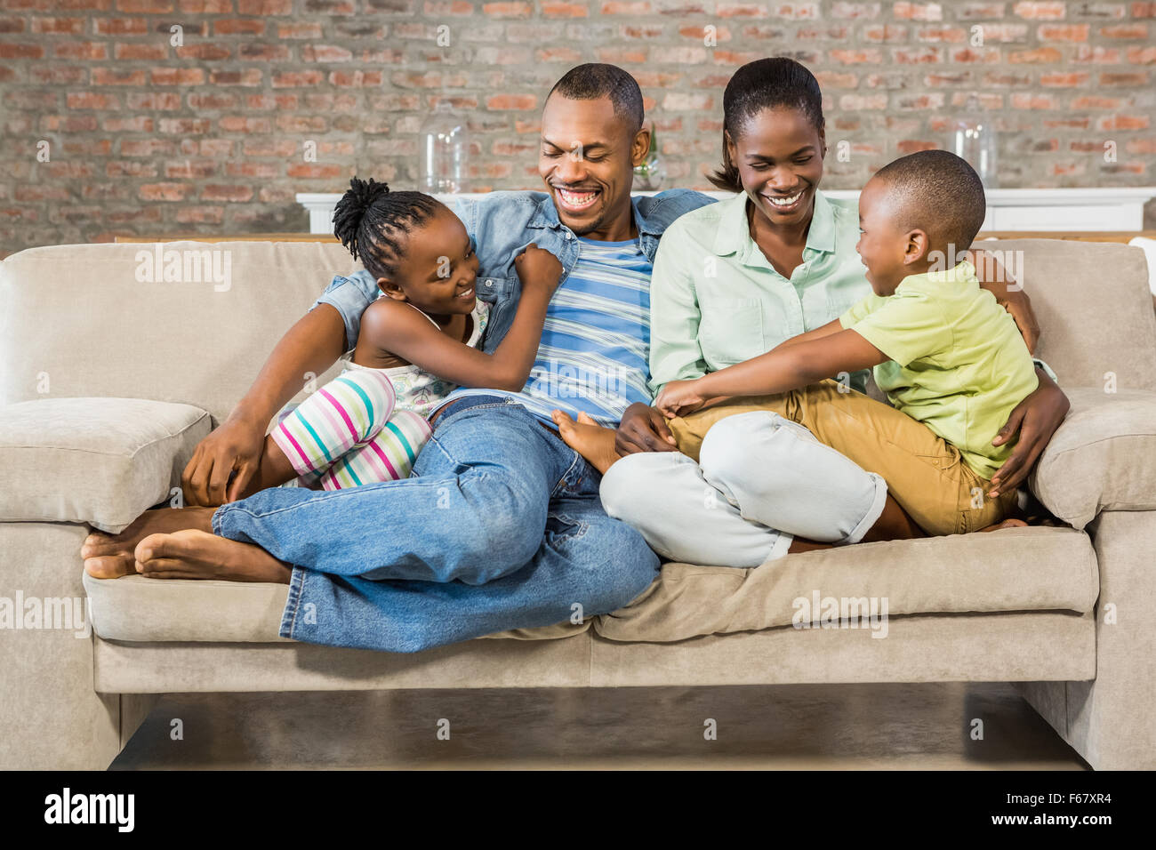Happy Family posing sur le canapé Banque D'Images
