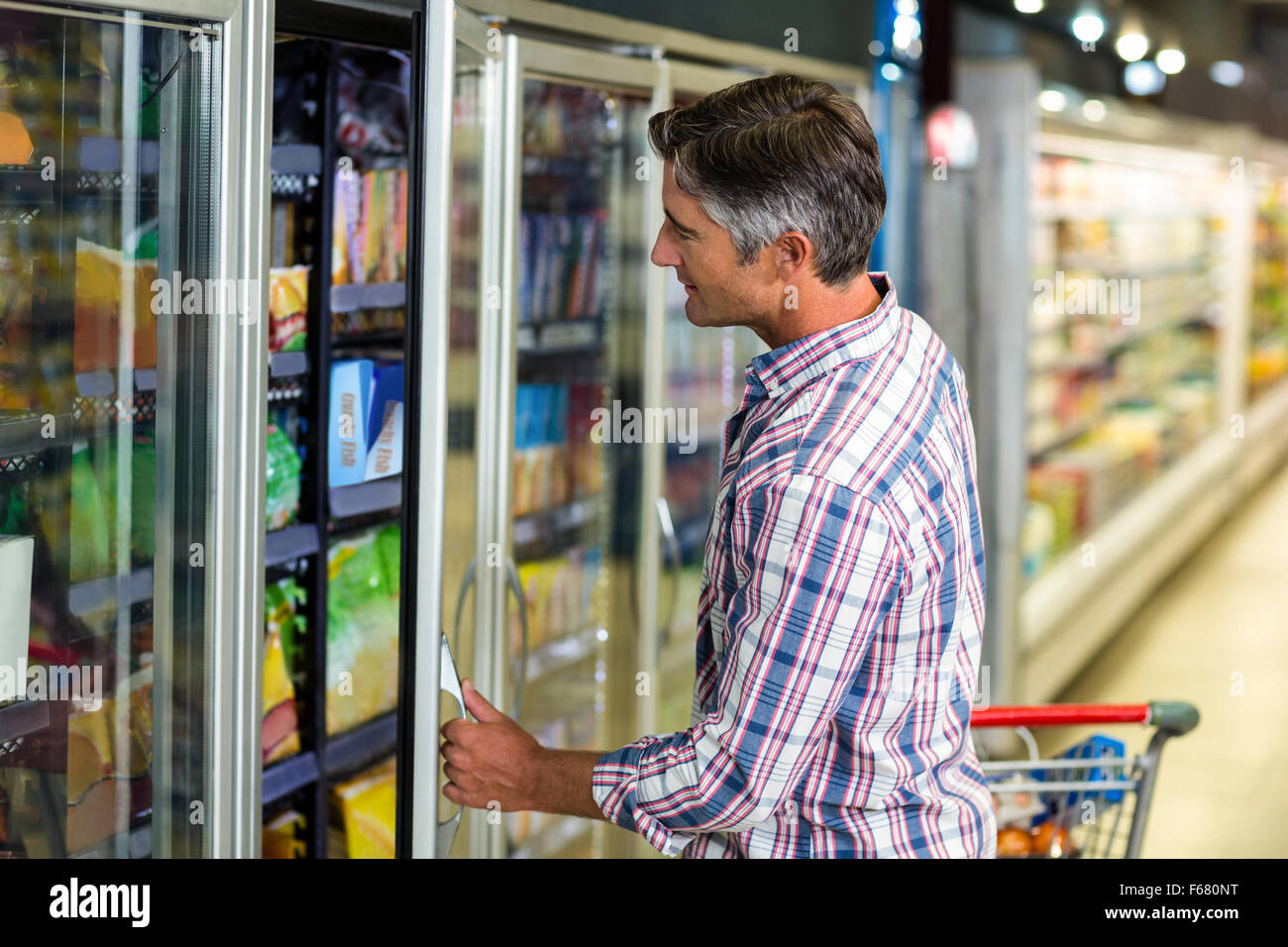 Man opening supermarché réfrigérateur Banque D'Images