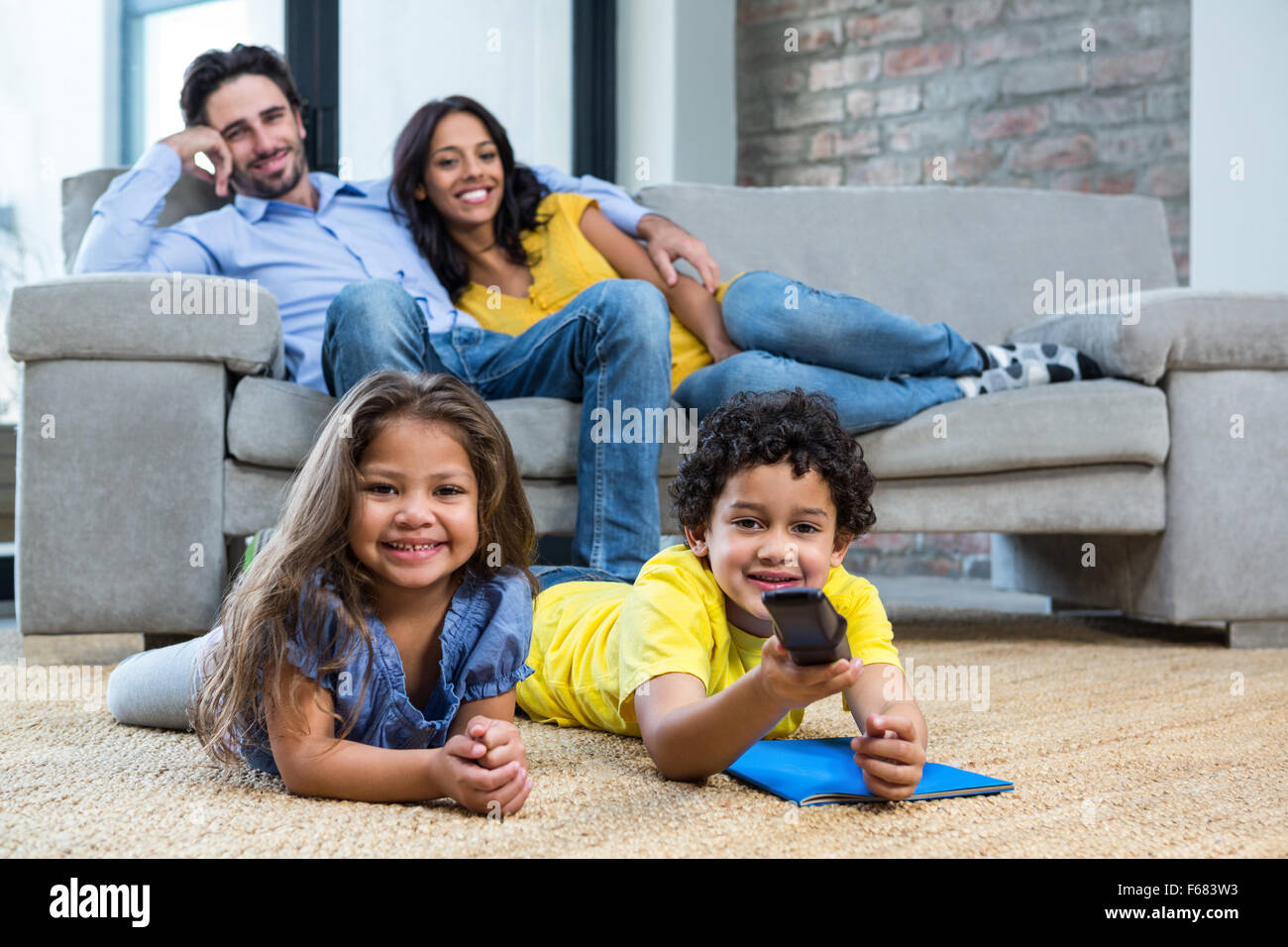 Smiling family in living room à plat Banque D'Images