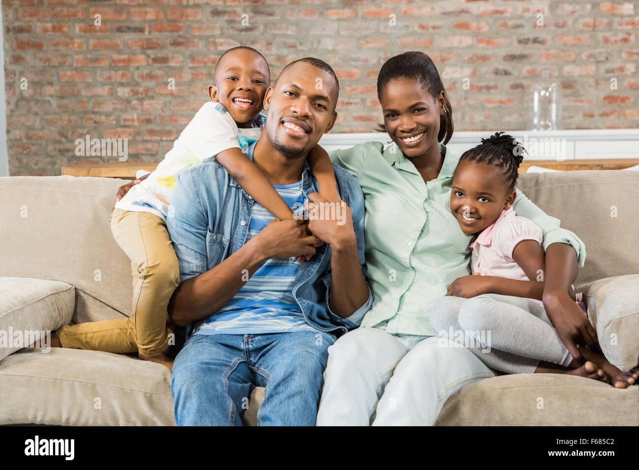 Famille heureuse de vous détendre sur le canapé Banque D'Images