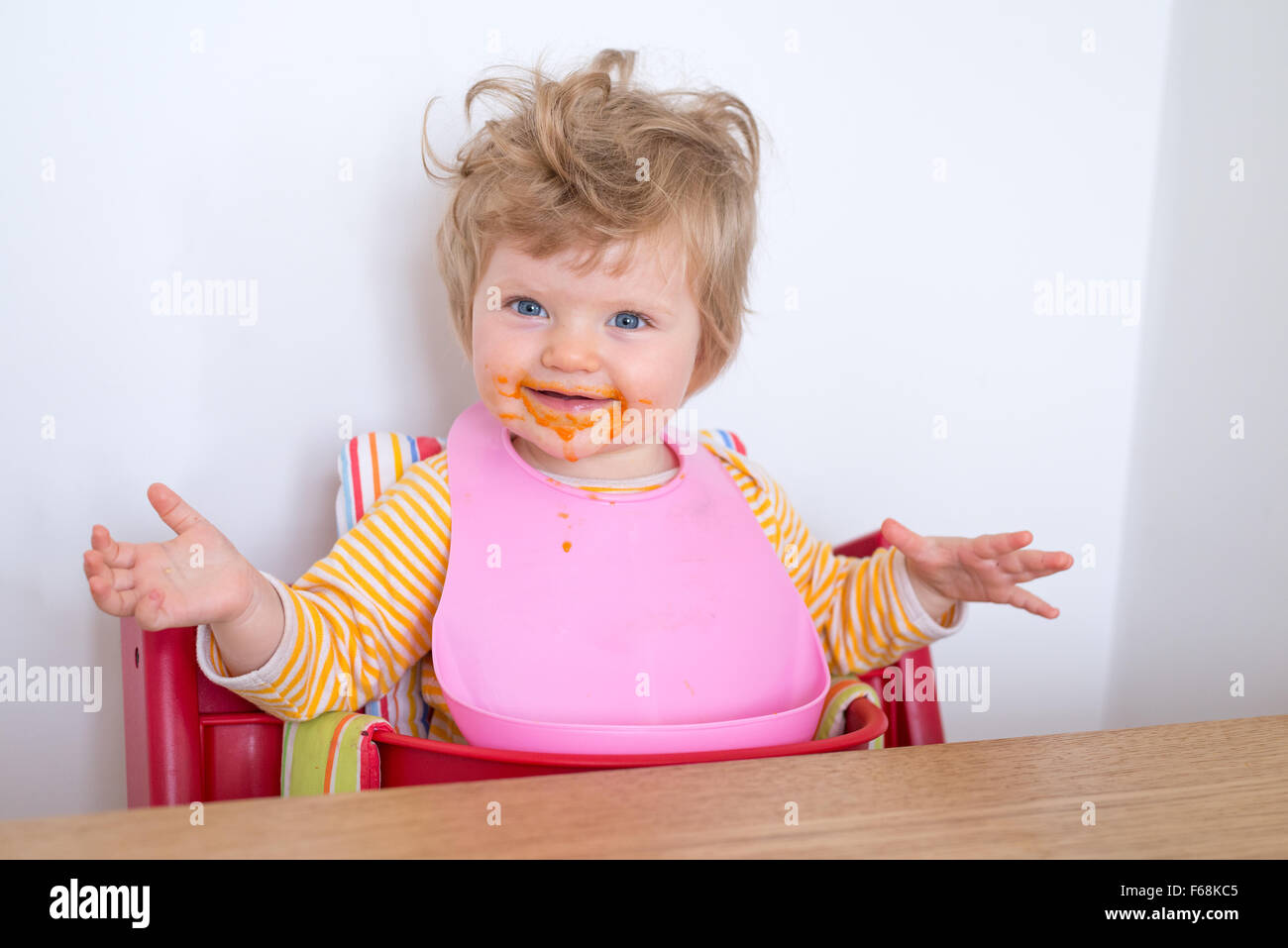 Un an bébé salissent en mangeant, England, UK Banque D'Images