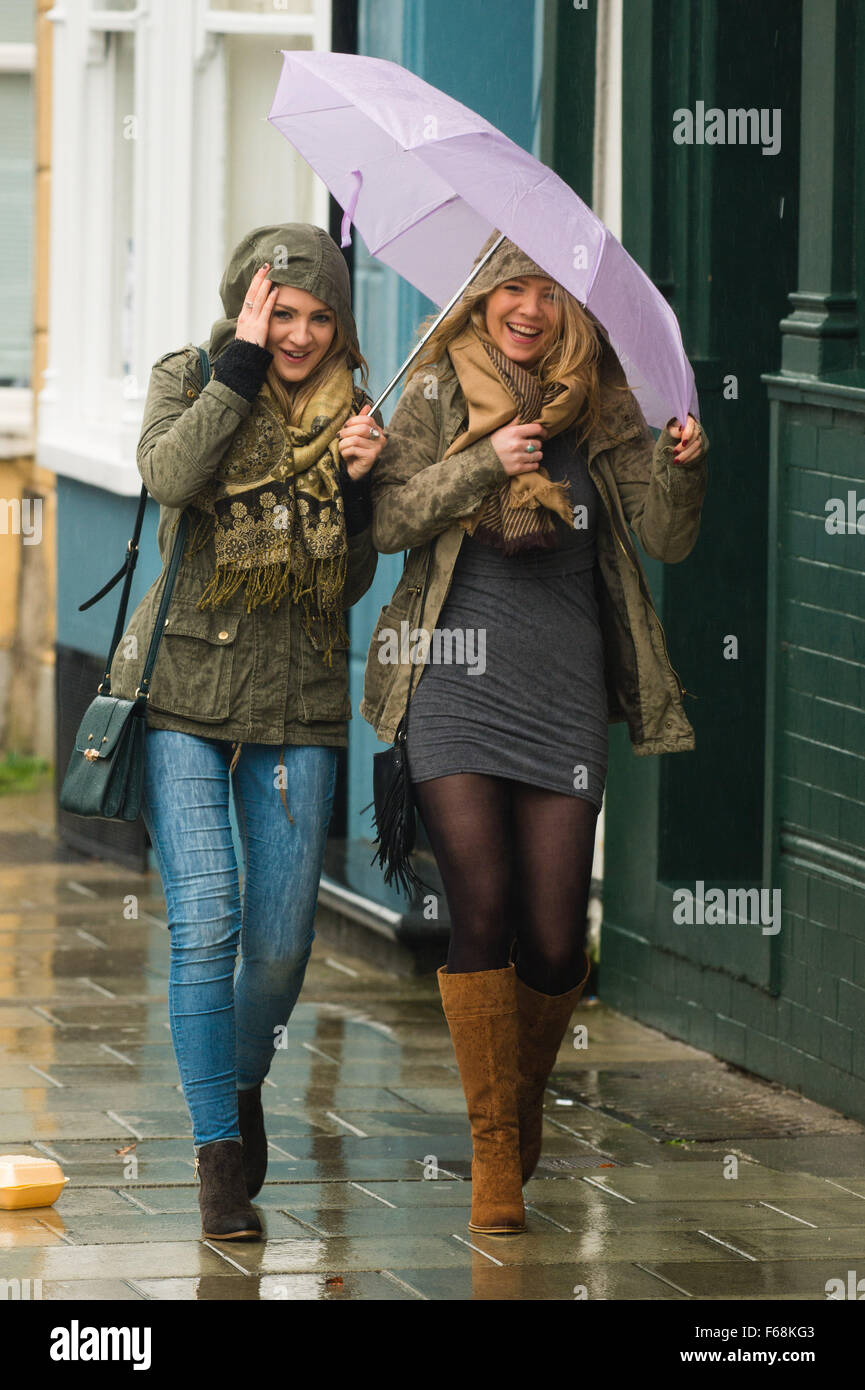 Pays de Galles Aberystwyth UK, Samedi 14 Novembre 2015 Deux jeunes femmes lutte éviter d'être trempé dans les rues d'Aberystwyth, comme une bande de pluie torrentielle sweeps en provenance de l'ouest dans le service d'Abigail. Ambre et rouge les avertissements sont en place pour le risque de graves inondations dans le nord du Pays de Galles et le nord ou l'Angleterre, avec jusqu'à 8" (20cm) de pluie prévue à l'automne sur sol déjà saturé dans certaines régions dans les prochaines 24 heures Crédit photo : Keith Morris /Alamy Live News Banque D'Images