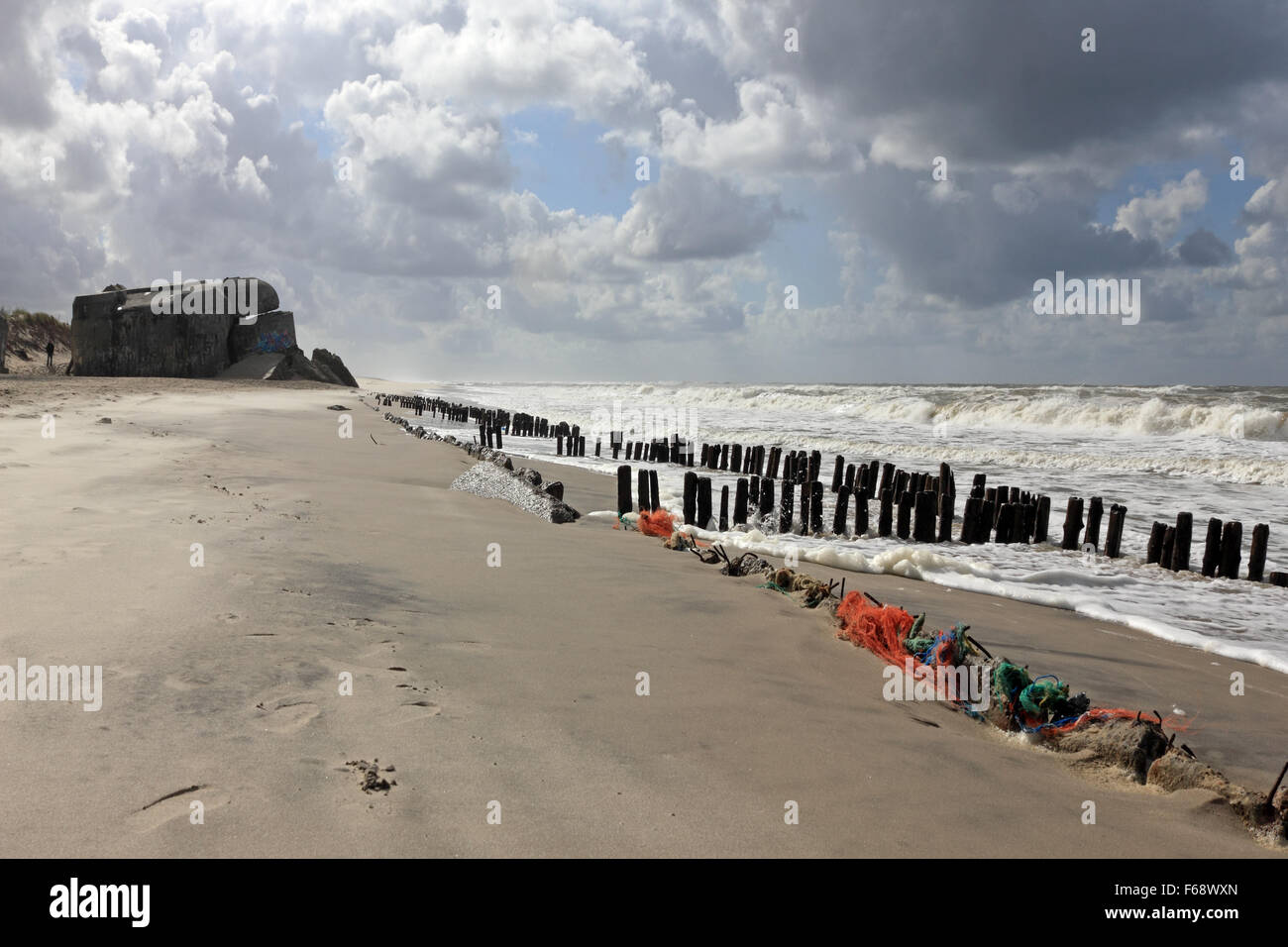 WW2 défense Nazi bunker et piquets en bois sur la plage à Houvig Strand, Søndervig, Jutland, Danemark. Banque D'Images