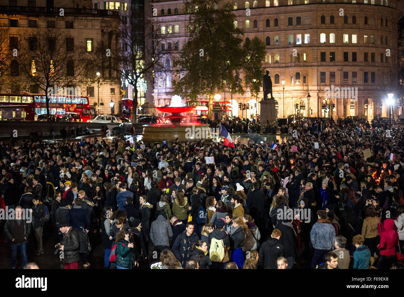 Londres, Royaume-Uni. 14 novembre, 2015. Des milliers de personnes se rassemblent à Trafalgar Square pour une veillée aux chandelles en solidarité avec les victimes d'attaques terroristes de la nuit dernière à Paris. La National Portrait Gallery est éclairé avec les couleurs de l'indicateur Tricolore Français. Banque D'Images
