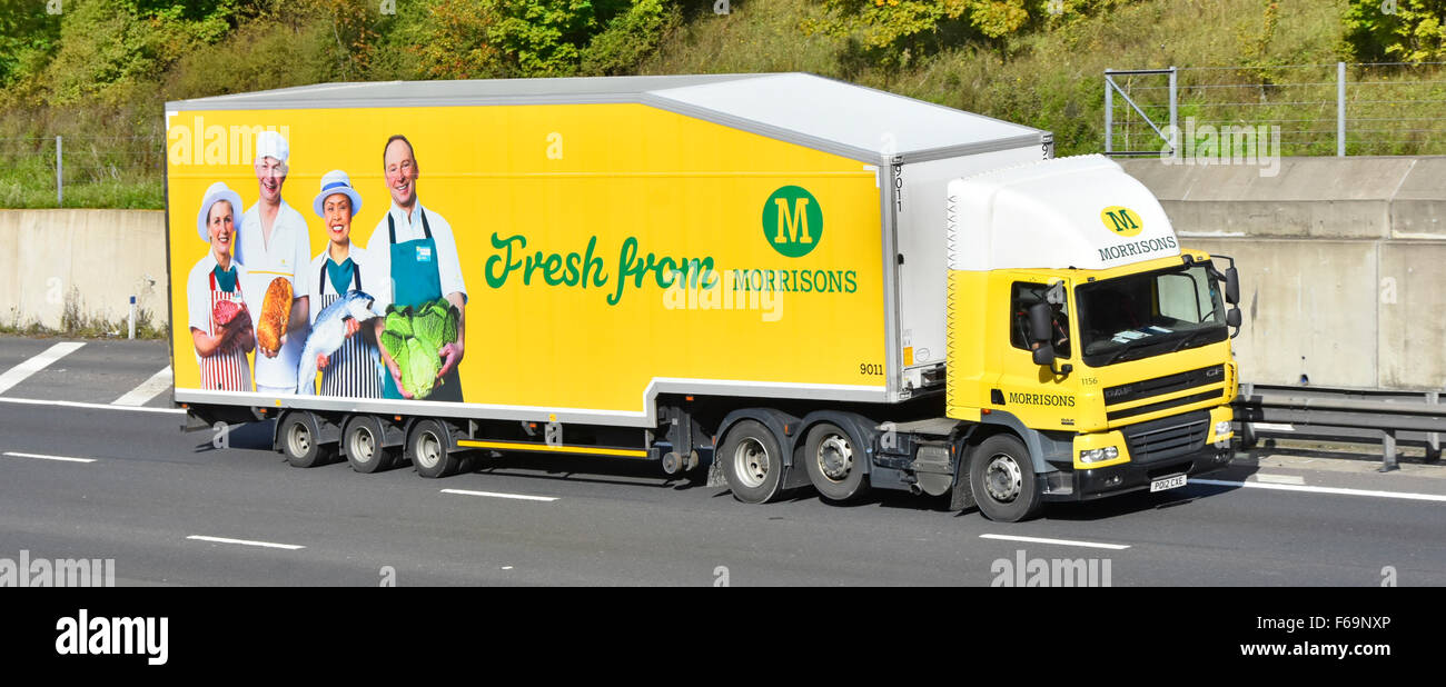 Logistique de la chaîne d'approvisionnement via le supermarché Morrisons livraison de camions hgv avec remorque annonçant la nourriture fraîche conduite le long de la route d'autoroute britannique anglaise Banque D'Images