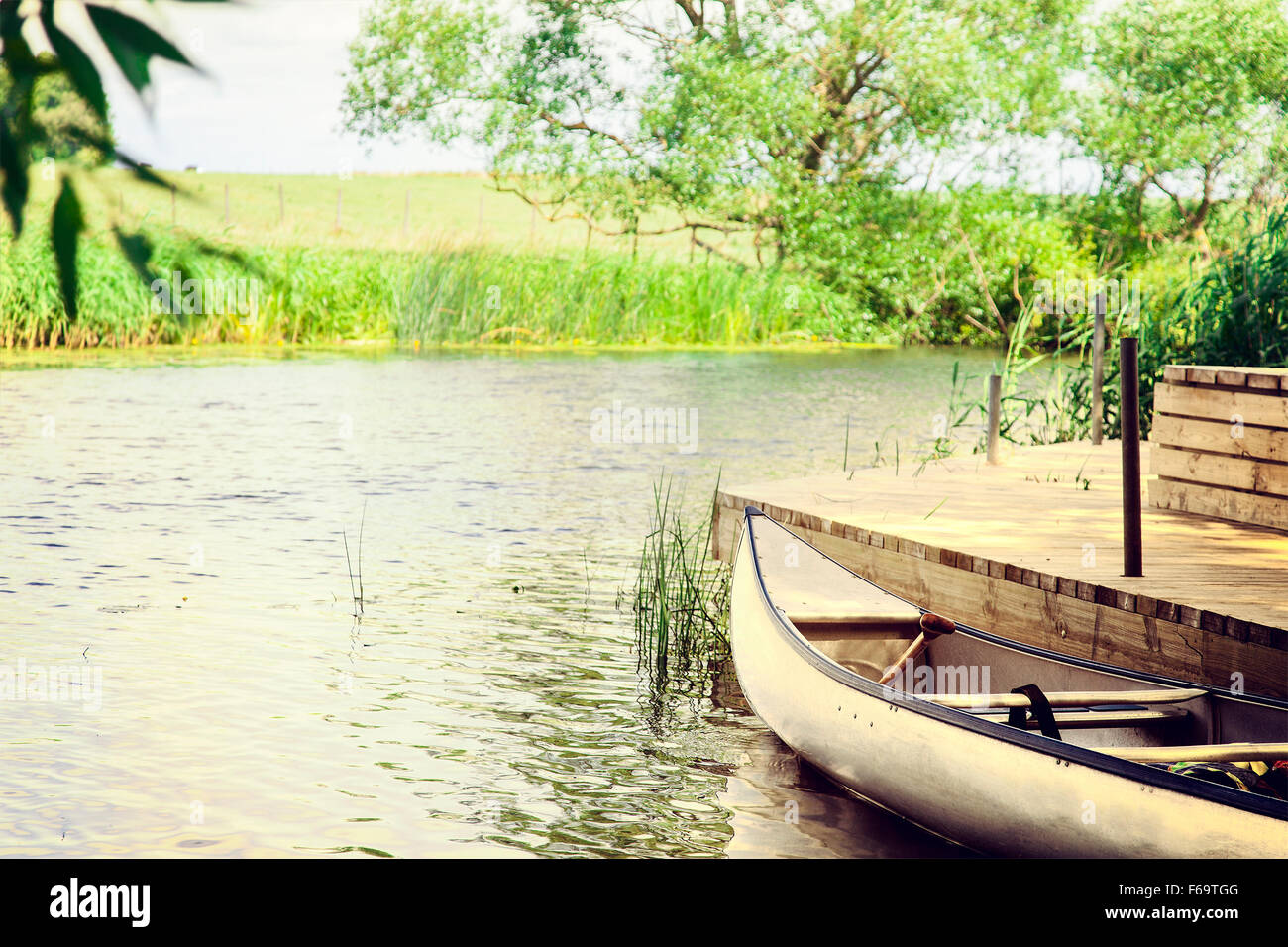 Image d'un canot à la rive du fleuve un jour d'été. De style vintage. Banque D'Images