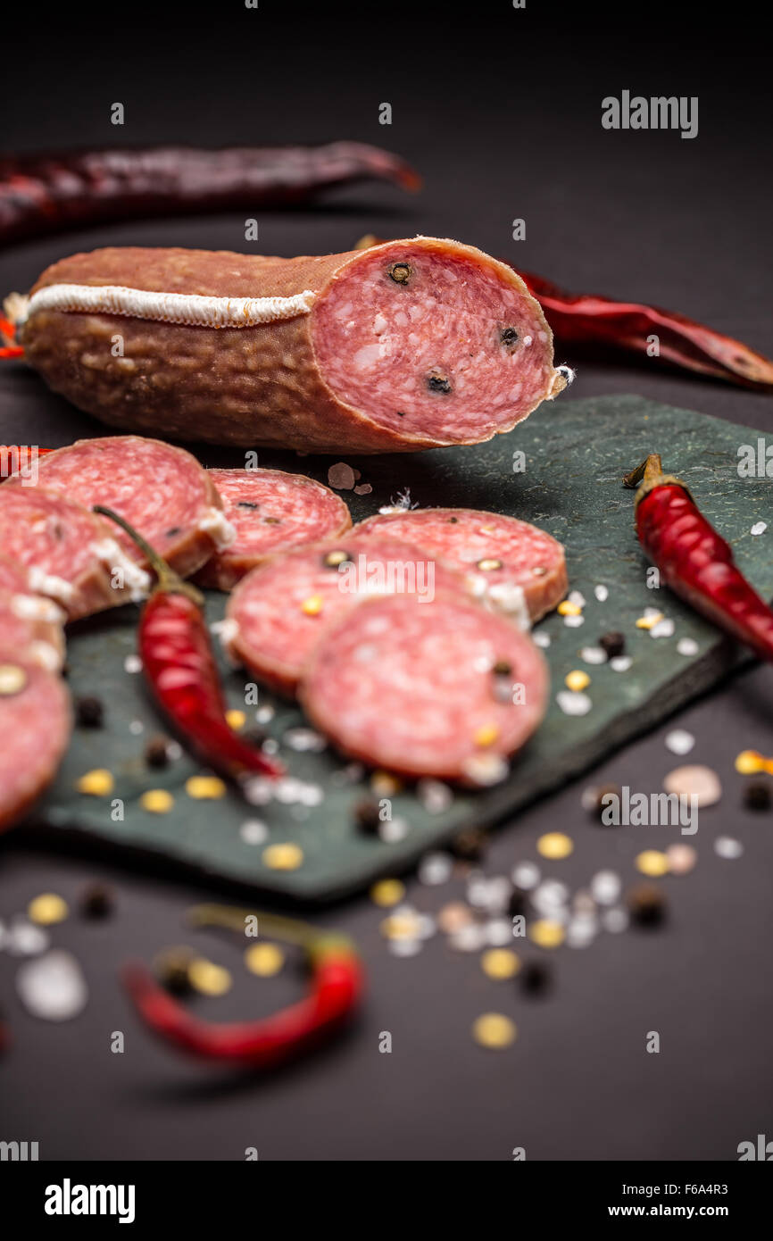 Salami délicieux sur fond noir Banque D'Images