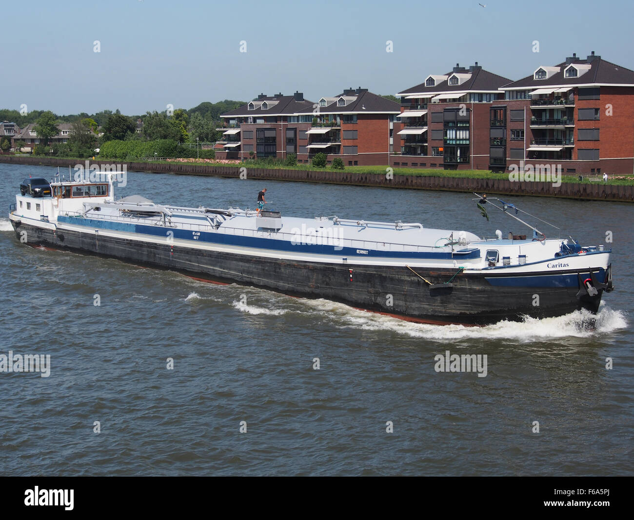 L'image montre la Caritas, un navire ENI 02309837 naviguant sur l'Amsterdam-Rijnkanaal. Ce porte-conteneurs fait partie d'une opération logistique clé, transportant des marchandises telles que le charbon, le gaz et les marchandises générales. Banque D'Images