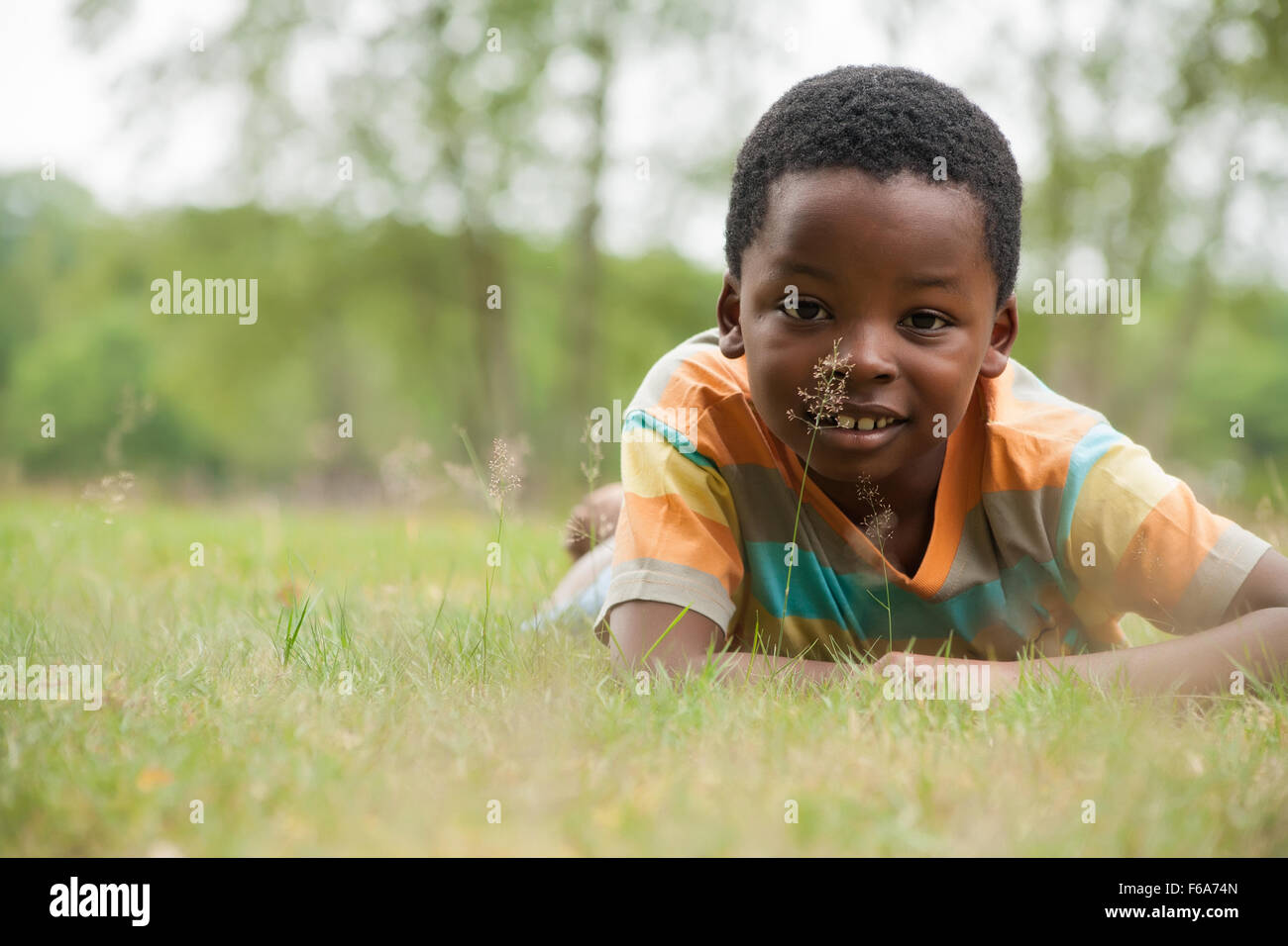 African boy est relacing dans l'herbe Banque D'Images