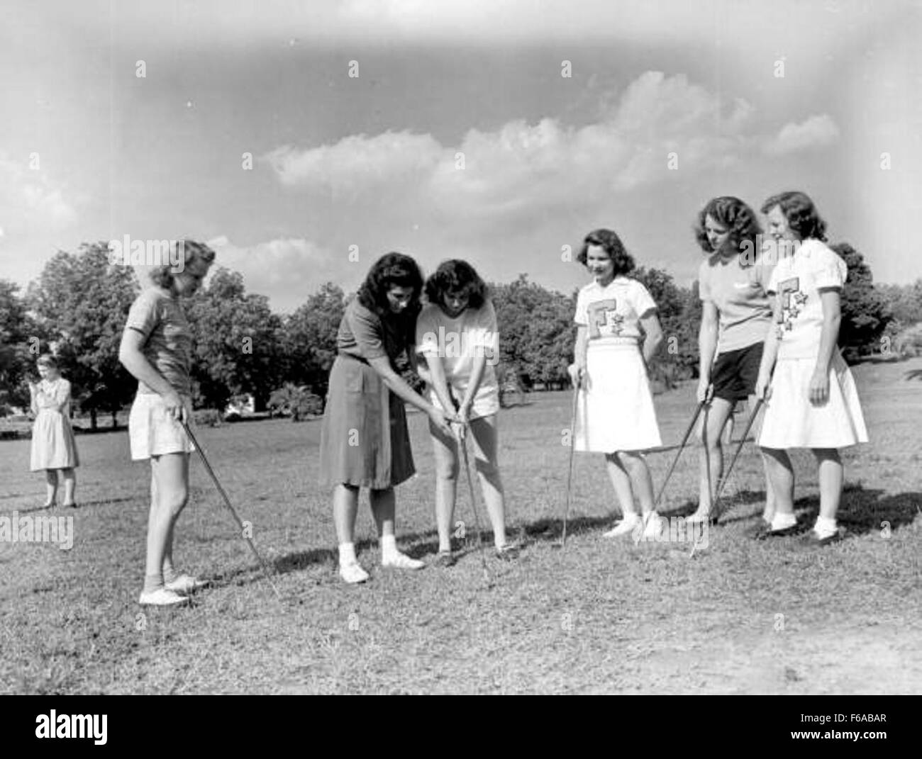 Étudiants pratiquant le golf avec leur professeur à Tallahassee. La scène reflète l'aspect éducatif du sport, où les élèves apprennent à la fois les compétences techniques et les valeurs du travail d'équipe et de la discipline dans le jeu de golf. Banque D'Images