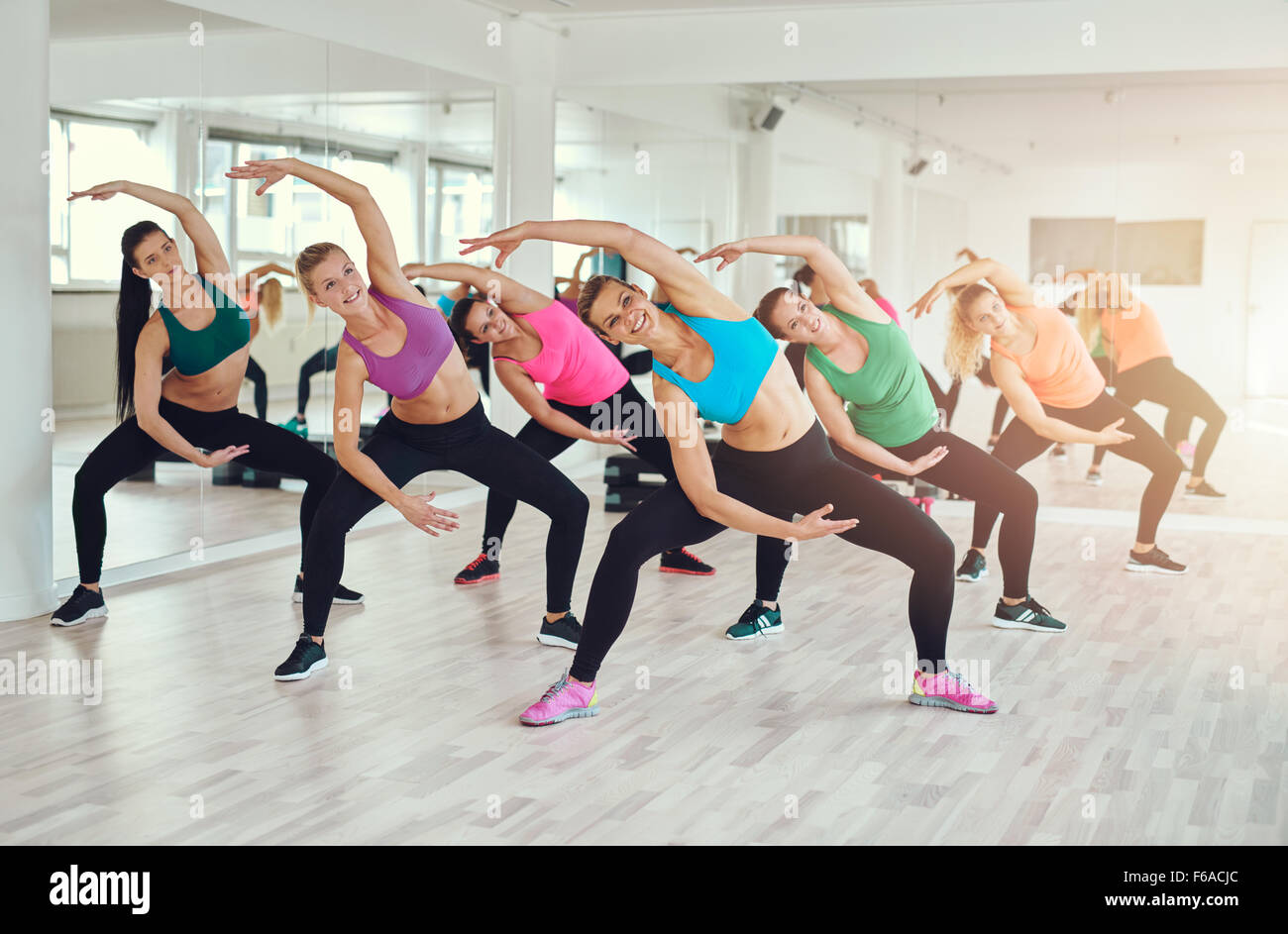 Cours d'aérobic dans une salle de sport avec un groupe de jeunes femmes dans l'élaboration dans les vêtements colorés, de synchronisation dans un w Banque D'Images