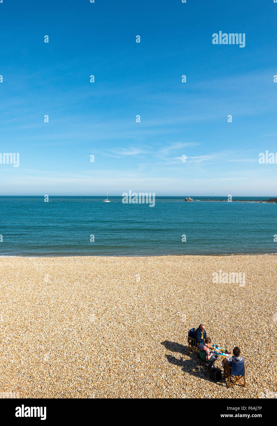 Regardant vers le bas sur un pique-nique en famille sur une plage de galets en pierre Banque D'Images