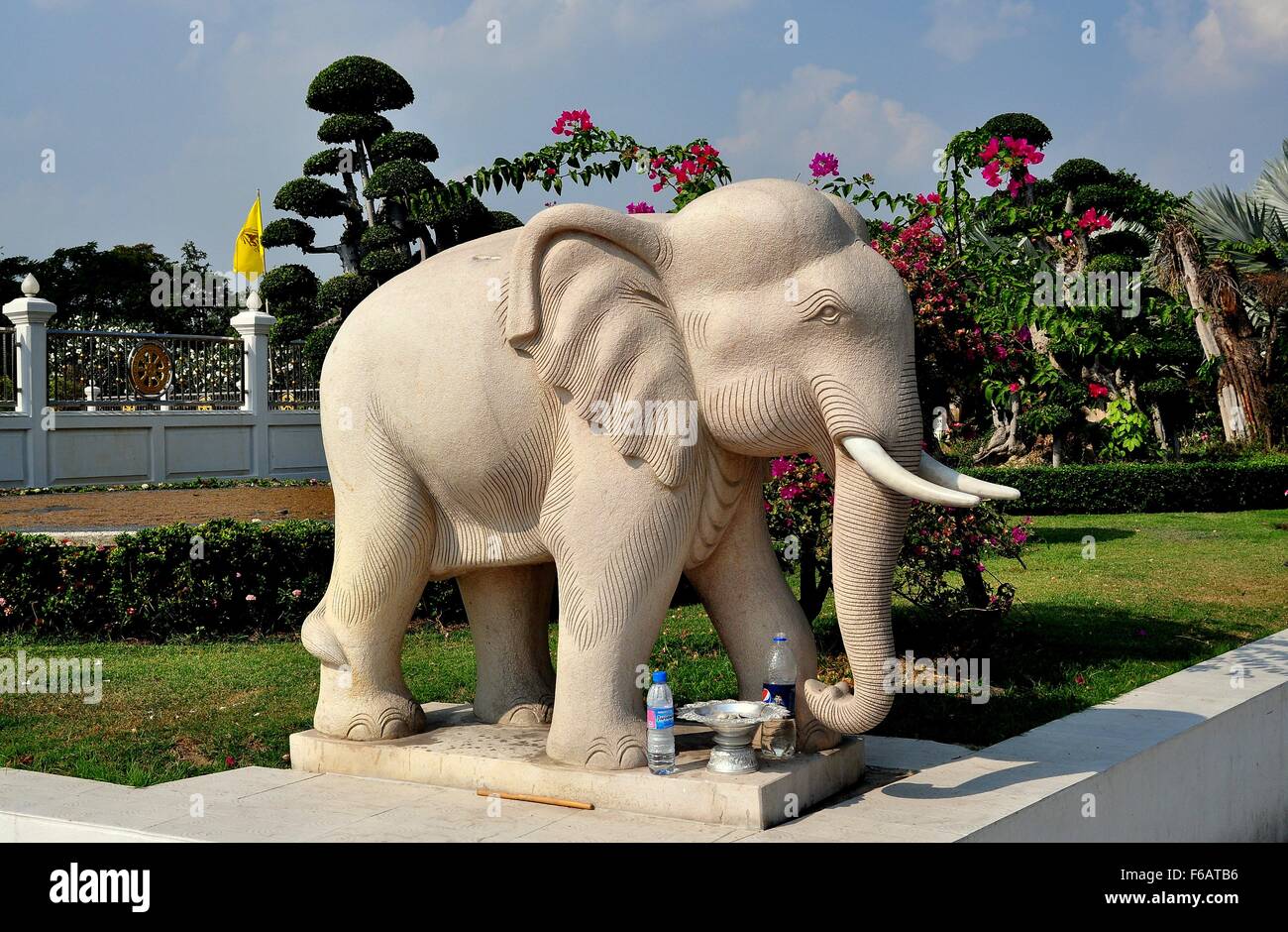 Samut Prakan, Thaïlande : Statue d'un vénéré Thai elephant complet avec deux bouteilles en plastique d'eau restant comme offrandes Banque D'Images