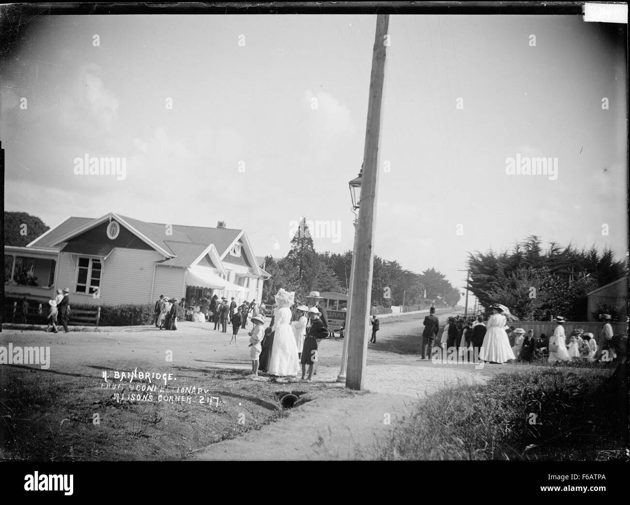 Le magasin de fruits et de confiserie Bainbridge à Alison's Corner à Takapuna était un magasin local populaire connu pour sa large sélection de fruits et de bonbons. Cette image historique capture le charme de la boutique dans sa splendeur, mettant en valeur un élément de base du paysage commercial de Takapuna. Banque D'Images