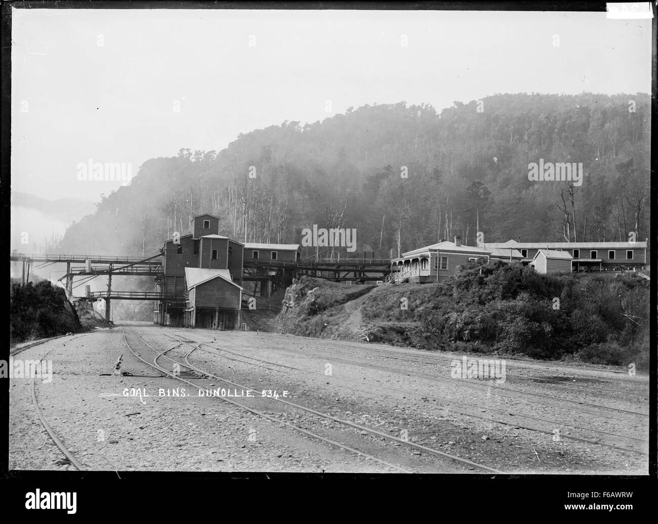 Cette photographie montre des bacs à charbon situés le long de la ligne de chemin de fer à Dunollie, dans le district gris, fournissant un enregistrement visuel des activités industrielles du début du XXe siècle. L’image reflète l’importance du transport du charbon et du réseau ferroviaire dans l’économie de la région à cette époque. Banque D'Images
