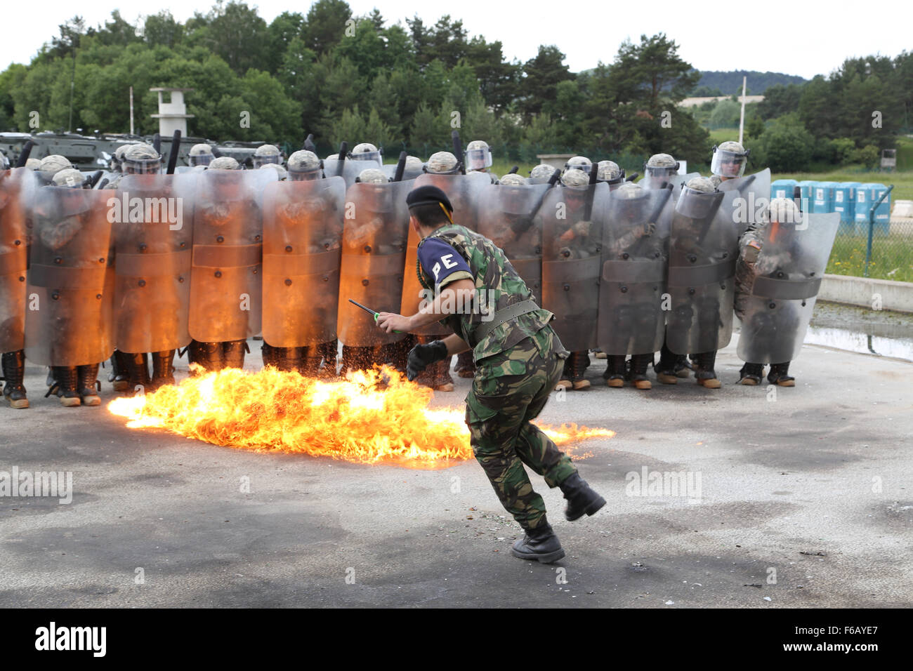 Les soldats américains du 1er bataillon du 252ème régiment blindé, vous déplacer dans le feu tandis qu'un soldat portugais jette un cocktail Molotov dans le cadre de la phobie du feu lors d'une formation de la Force du Kosovo (KFOR) de l'exercice de répétition de mission (MRE) au Centre de préparation interarmées multinationale à Hohenfels, Allemagne, le 16 juin 2015. La KFOR MRE est basé sur l'environnement opérationnel courant et est conçu pour préparer l'unité de maintien de la paix, de la stabilité, et des plans d'opérations au Kosovo au soutien aux autorités civiles pour maintenir un environnement sûr et sécuritaire. (U.S. Photo de l'armée par la CPS. Tyler Kingsbury/libérés) Banque D'Images