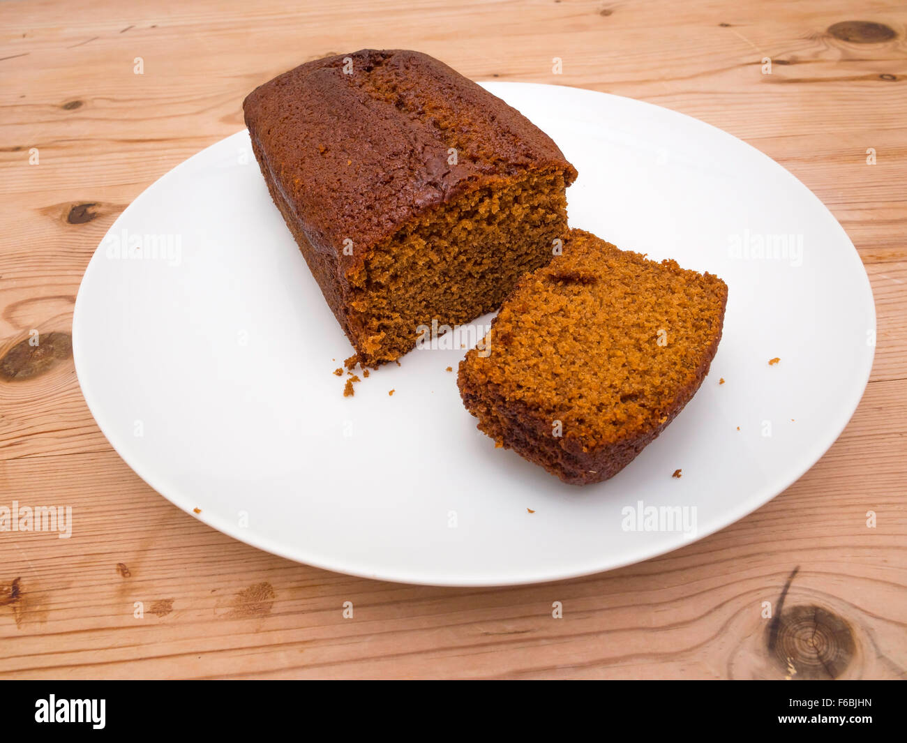 Yorkshire Parkin ou Perkin un gâteau traditionnel à base de mélasse d'avoine et le gingembre plaque blanche table en bois coupé en tranches Banque D'Images