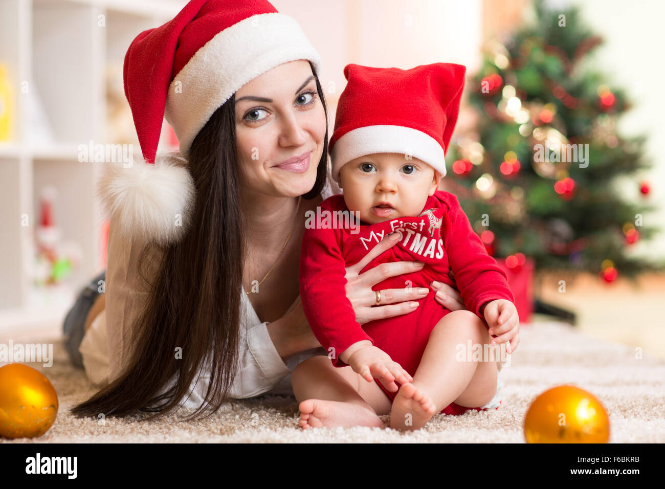 Heureuse mère et bébé adorable en fonction de Santa Banque D'Images