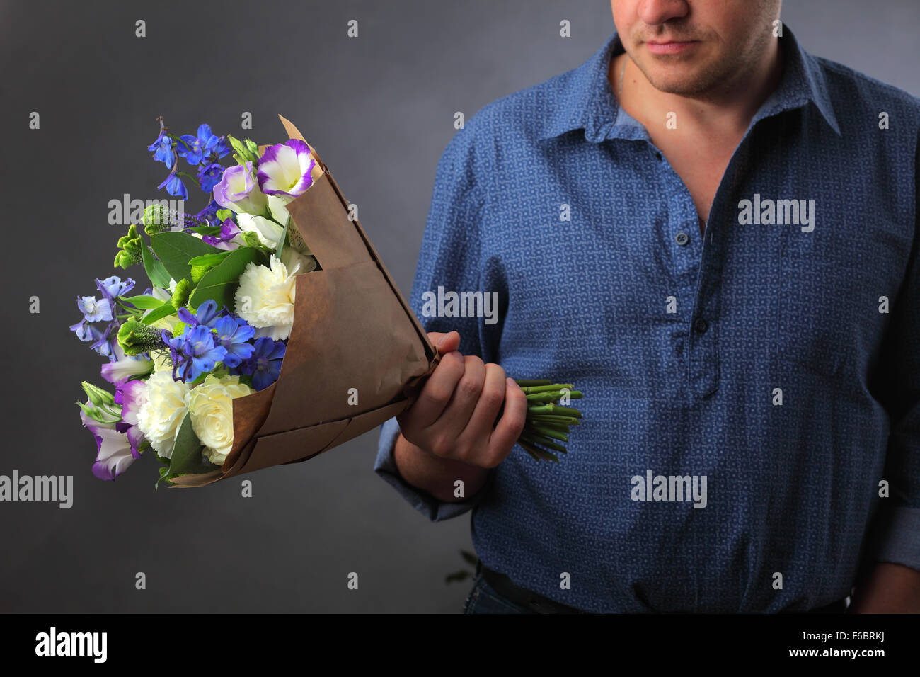 Homme tenant un bouquet de fleurs, un homme fait une proposition d'une femme, un amoureux des fleurs et une bague, l'amour caché note dans les fleurs, note maîtresse, Banque D'Images