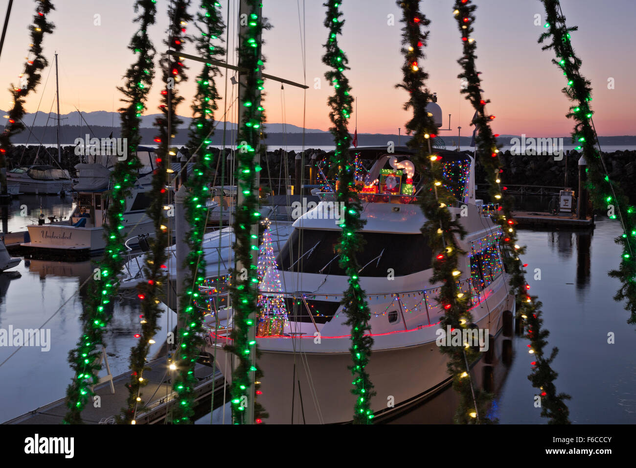 WASHINGTON - bateaux au port de plaisance d'Edmonds décoré pour la saison de vacances, avec la Puget Sound et les montagnes olympiques au-delà Banque D'Images