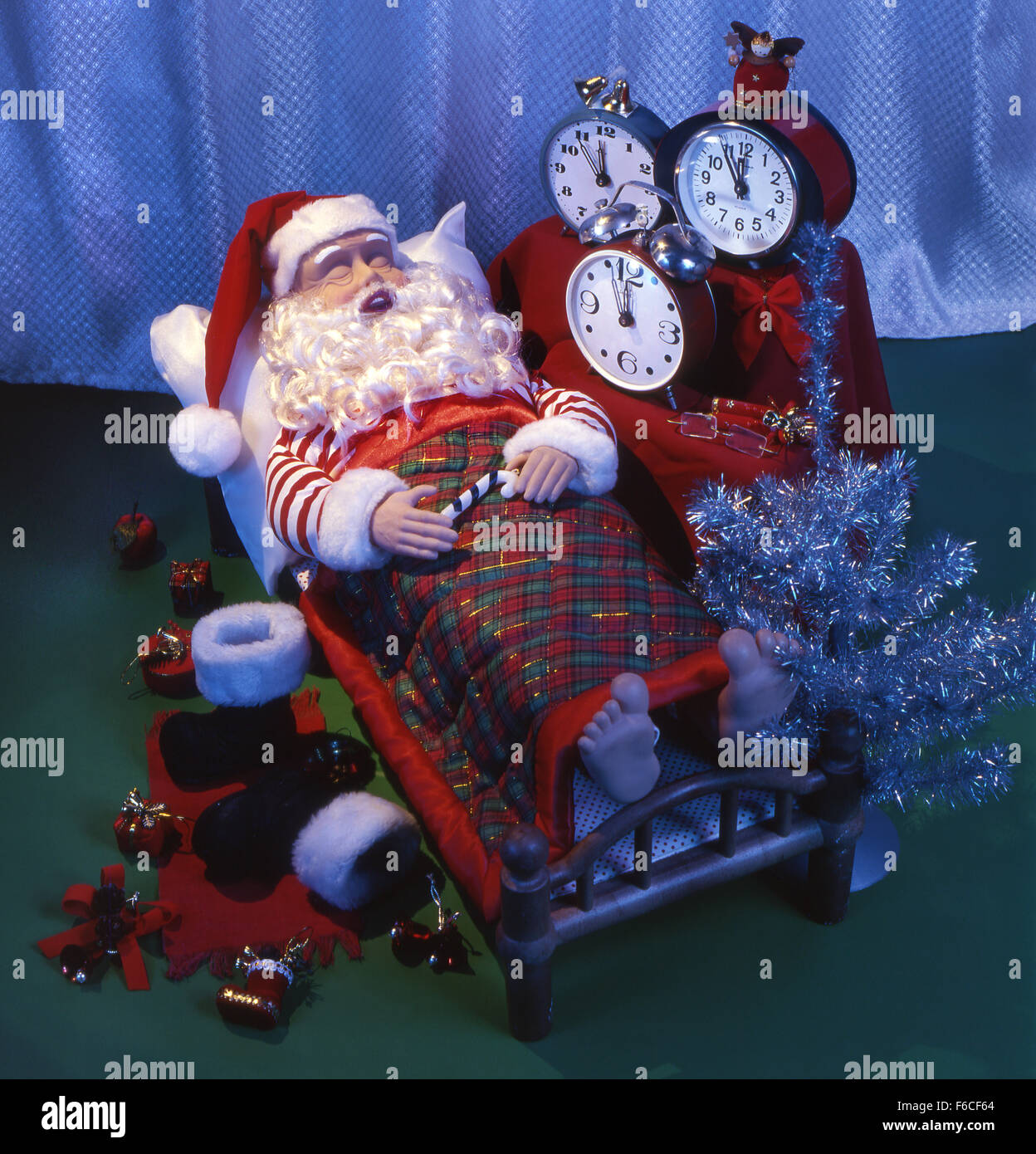 Les fêtes de Nouvel An, Noël encore la vie avec des jouets-santa dort sur un lit c'heures jusqu'à un réveil ne réactive pas. Banque D'Images