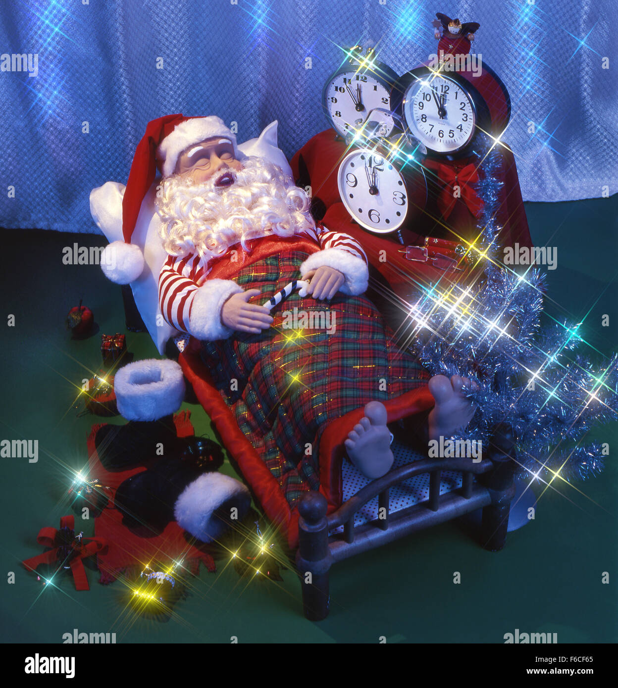 Les fêtes de Nouvel An, Noël encore la vie avec des jouets-santa dort sur un lit c'heures jusqu'à un réveil ne réactive pas. Banque D'Images