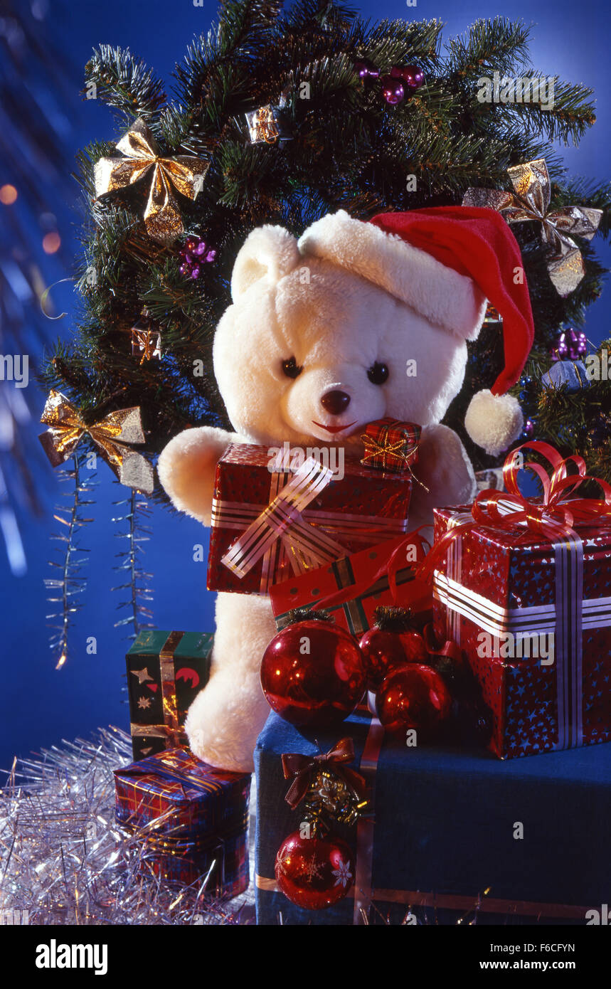 La nouvelle année de fête, Noël encore la vie d'un ours en peluche avec des cadeaux dans les boîtes et une couronne de Noël. format vertical. fond bleu Banque D'Images