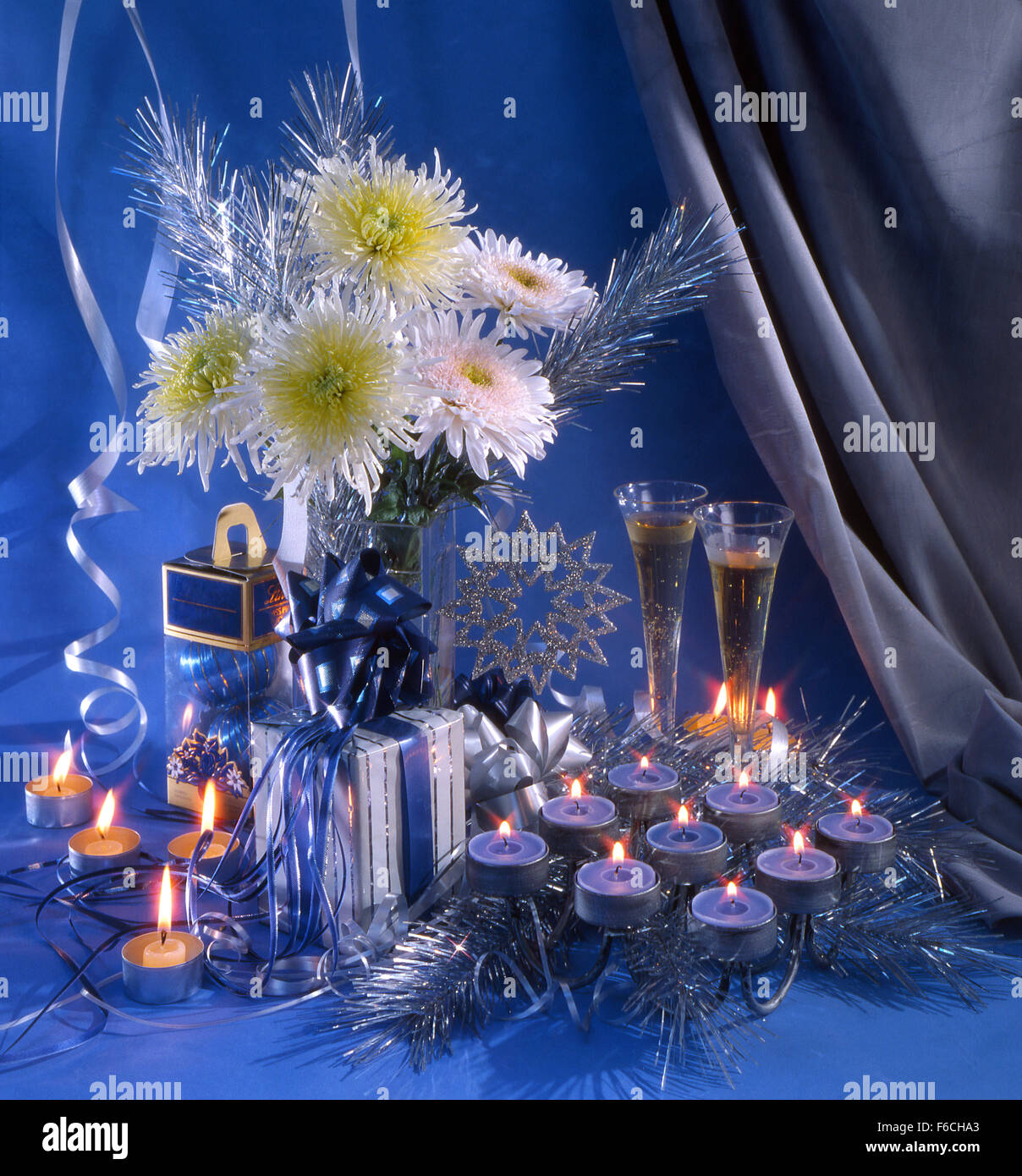 La nouvelle année de fête, Noël encore la vie avec deux verres de vin, un bouquet de chrysanthèmes blancs et un chandelier Banque D'Images