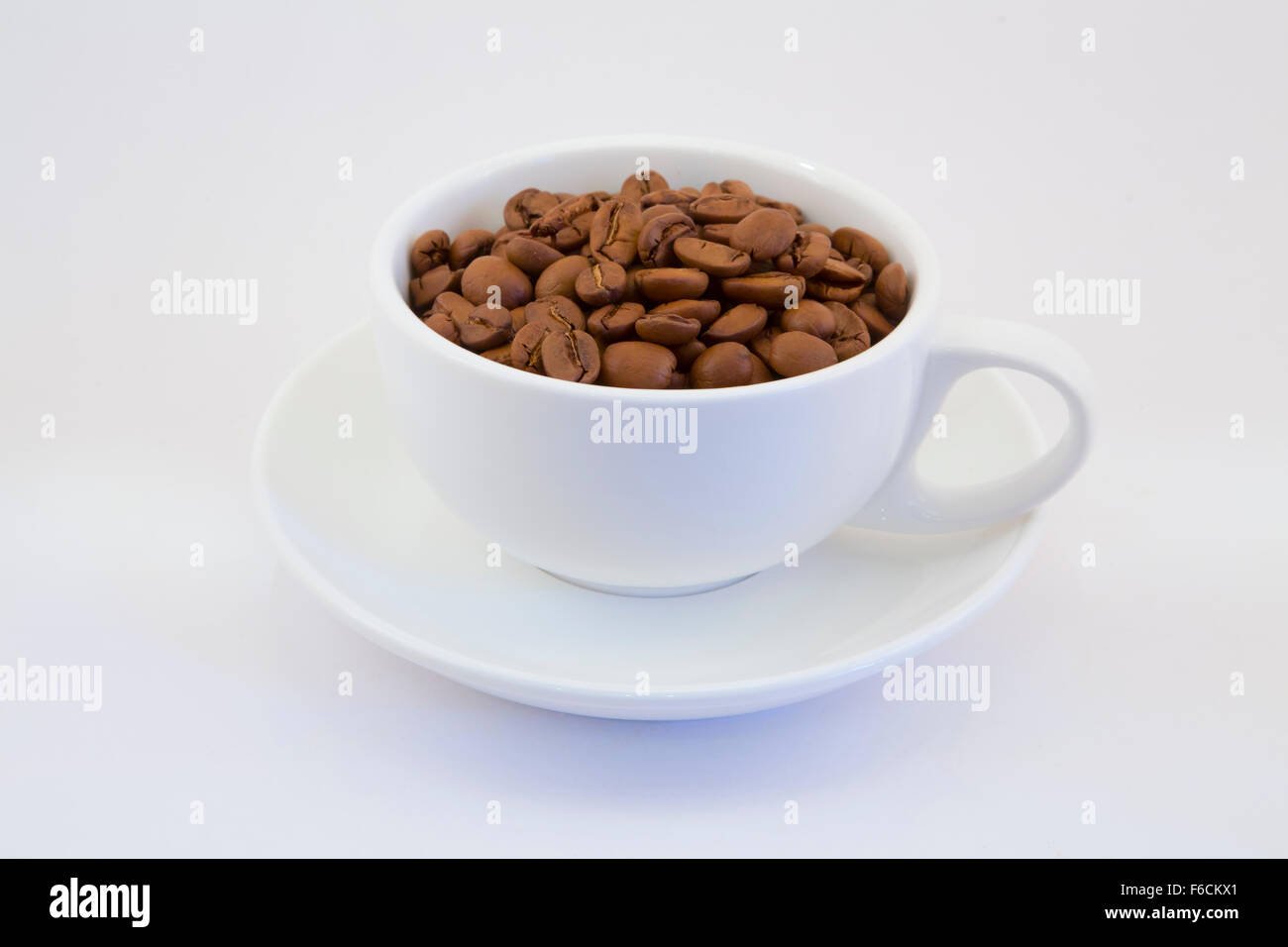 Tasse de café fraîchement torréfié tenant ensemble les grains de café au sol Banque D'Images