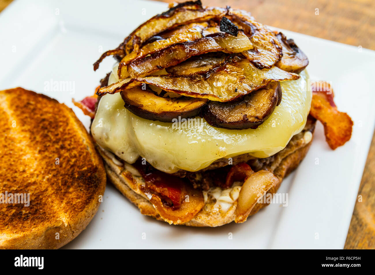 Un champignon, Swiss, bacon, oignons sautés, hamburger sur un petit pain de blé entier grillé Banque D'Images