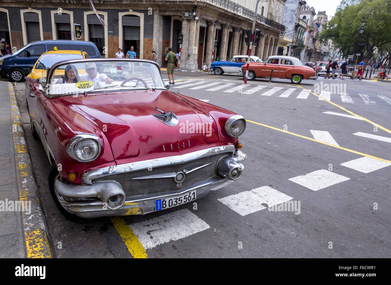 Deux touristes assis dans une vieille décapotable en attente d'une sightseeingtour dans le vieux Havane, vieille voiture, voiture vintage rouge sur le stree Banque D'Images