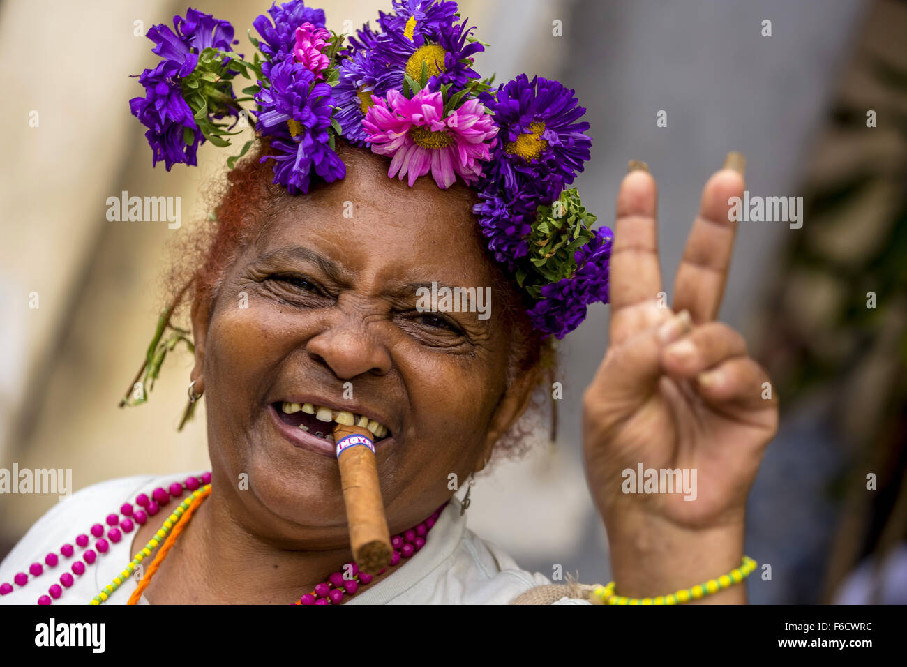 Signe de Paix, la vieille femme cubaine avec des fleurs et de cigare posant pour une astuce pour les touristes, La Habana, La Habana, La Havane, Cuba, Banque D'Images