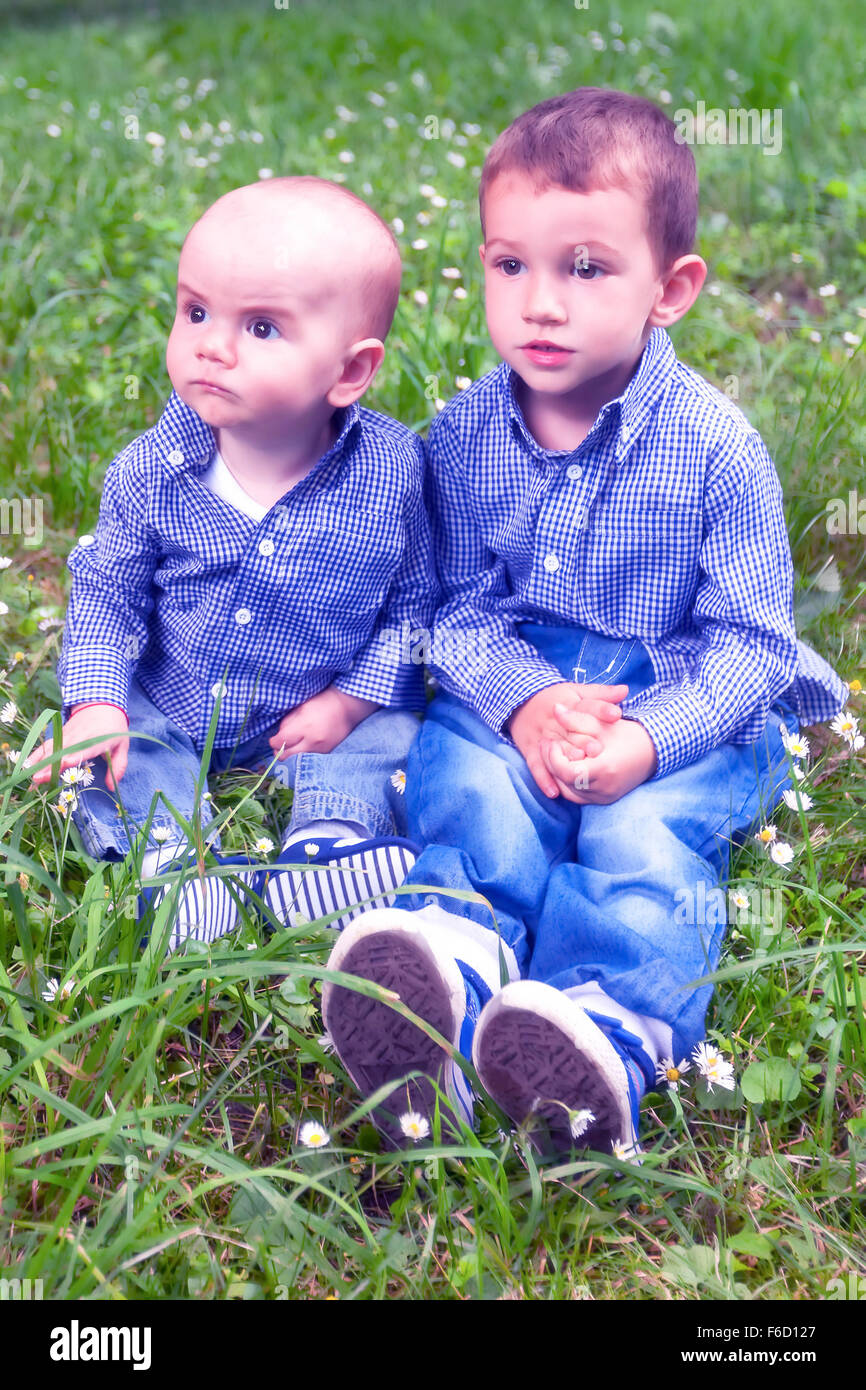 Portrait de deux jeunes frères assis dans l'herbe verte Banque D'Images