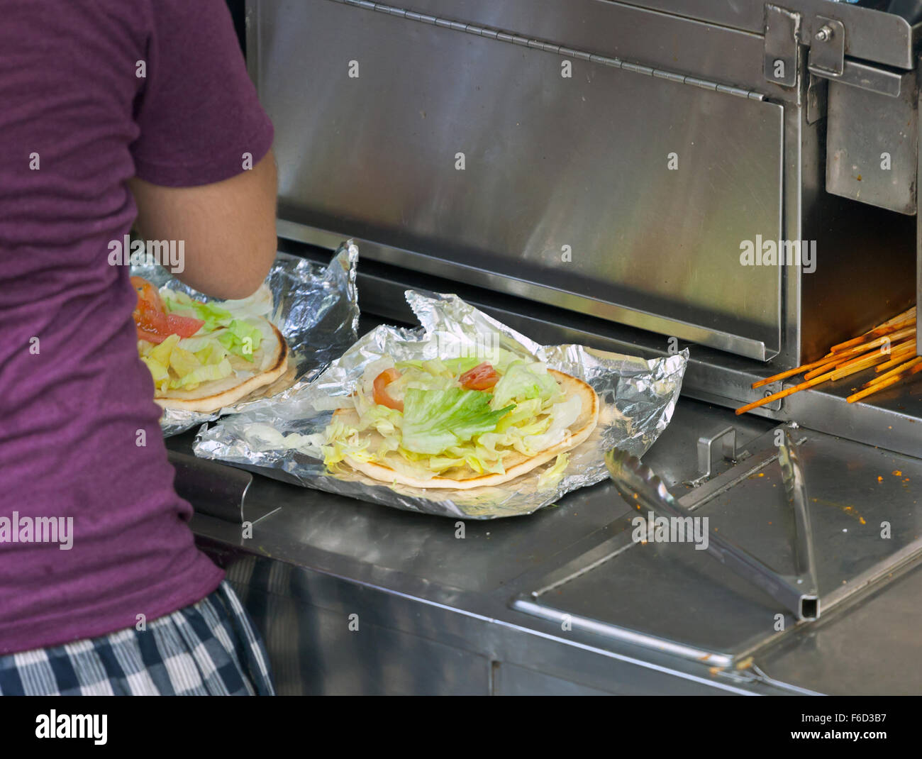 Street food vendor prépare un pain plat avec salade et d'autres ingrédients. New York City, USA. Banque D'Images