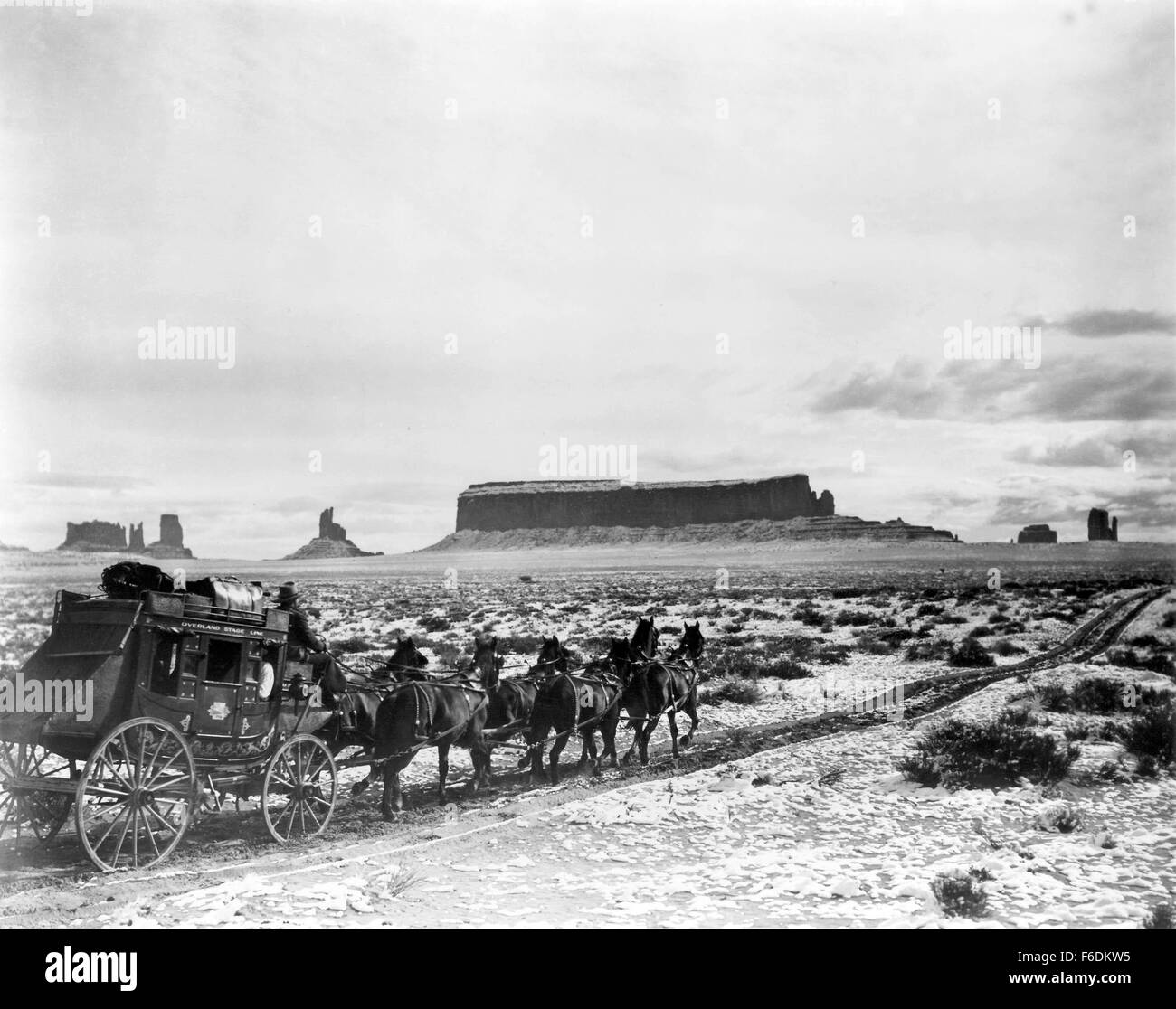 Titre du film : STAGECOACH. Réalisateur : John Ford. STUDIO : United Artists. PLOT : Un classique de l'ouest d'Hollywood sur un périlleux voyage à travers l'Overland Stagecoach territoire indien hostile. Les passagers à l'entraîneur : Un joueur 'Hatfield,' (John Carradine), un médecin ivre, Boone 'Doc' (Thomas Mitchell), une femme enceinte "Lucy" (Louise Platt), un directeur de banque qui a pris son essor avec l'argent de son client, "Henry Gatewood' (Berton Churchill), une prostituée au cœur d'or 'Dallas' (Claire Trevor), et le fameux Ringo Kid (John Wayne). Banque D'Images