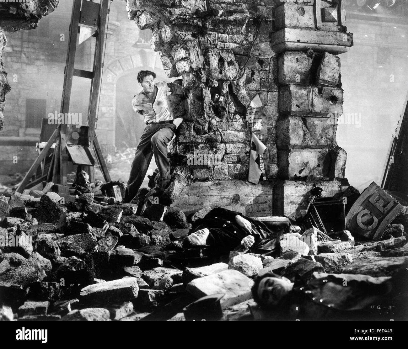 DATE DE SORTIE : Avril 22, 1944. Titre du film : Gloire incertaine. STUDIO : Warner Bros Pictures . Résumé : Au cours de la DEUXIÈME GUERRE MONDIALE, en France, Jean Picard est un criminel qui est sur le point d'être exécutées via la guillotine, mais d'un raid aérien interrompt elle et lui permet de s'échapper. Les voies de l'inspecteur Bonet le descendre et lui apporte en retour. Mais en chemin, ils entendent qu'un pont ferroviaire vitale pour les allemands a été détruit, soi-disant par les agents. Les Allemands prendre 100 Français et menacent de les exécuter à moins que les saboteurs s'avancer. Picard qui préféreraient mourir aux mains de l'opposition par fusillade t Banque D'Images