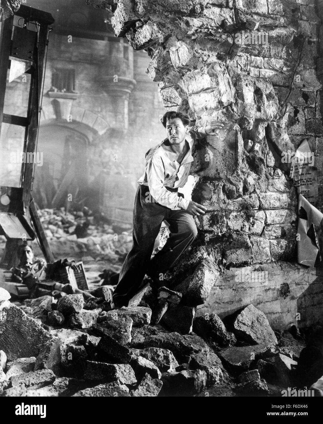 DATE DE SORTIE : Avril 22, 1944. Titre du film : Gloire incertaine. STUDIO : Warner Bros Pictures . Résumé : Au cours de la DEUXIÈME GUERRE MONDIALE, en France, Jean Picard est un criminel qui est sur le point d'être exécutées via la guillotine, mais d'un raid aérien interrompt elle et lui permet de s'échapper. Les voies de l'inspecteur Bonet le descendre et lui apporte en retour. Mais en chemin, ils entendent qu'un pont ferroviaire vitale pour les allemands a été détruit, soi-disant par les agents. Les Allemands prendre 100 Français et menacent de les exécuter à moins que les saboteurs s'avancer. Picard qui préféreraient mourir aux mains de l'opposition par fusillade t Banque D'Images