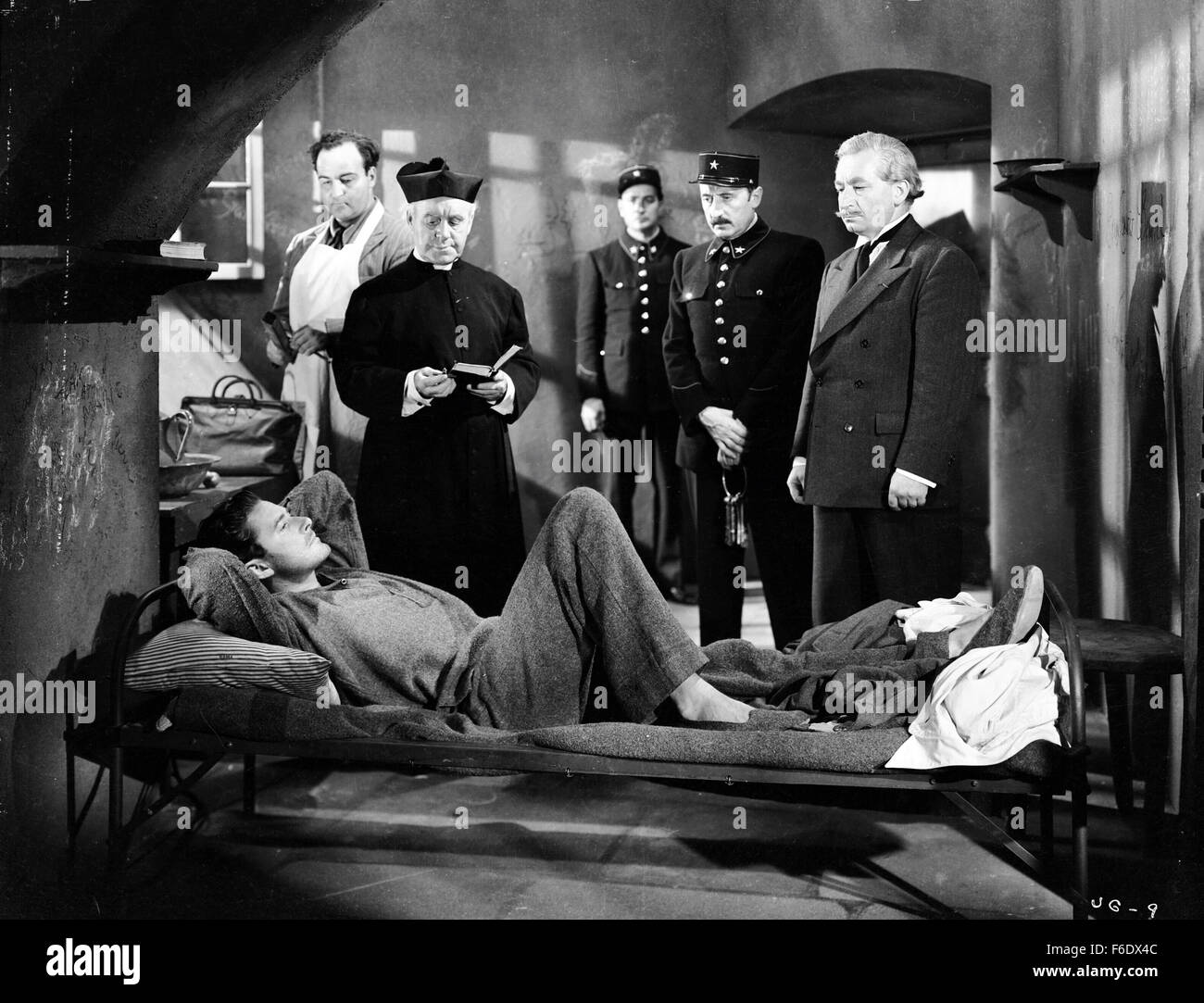 DATE DE SORTIE : Avril 22, 1944. Titre du film : Gloire incertaine. STUDIO : Warner Bros Pictures . Résumé : Au cours de la DEUXIÈME GUERRE MONDIALE, en France, Jean Picard est un criminel qui est sur le point d'être exécutées via la guillotine, mais d'un raid aérien interrompt elle et lui permet de s'échapper. Les voies de l'inspecteur Bonet le descendre et lui apporte en retour. Mais en chemin, ils entendent qu'un pont ferroviaire vitale pour les allemands a été détruit, soi-disant par les agents. Les Allemands prendre 100 Français et menacent de les exécuter à moins que les saboteurs s'avancer. Picard qui préféreraient mourir aux mains de l'opposition par fusillade t Banque D'Images