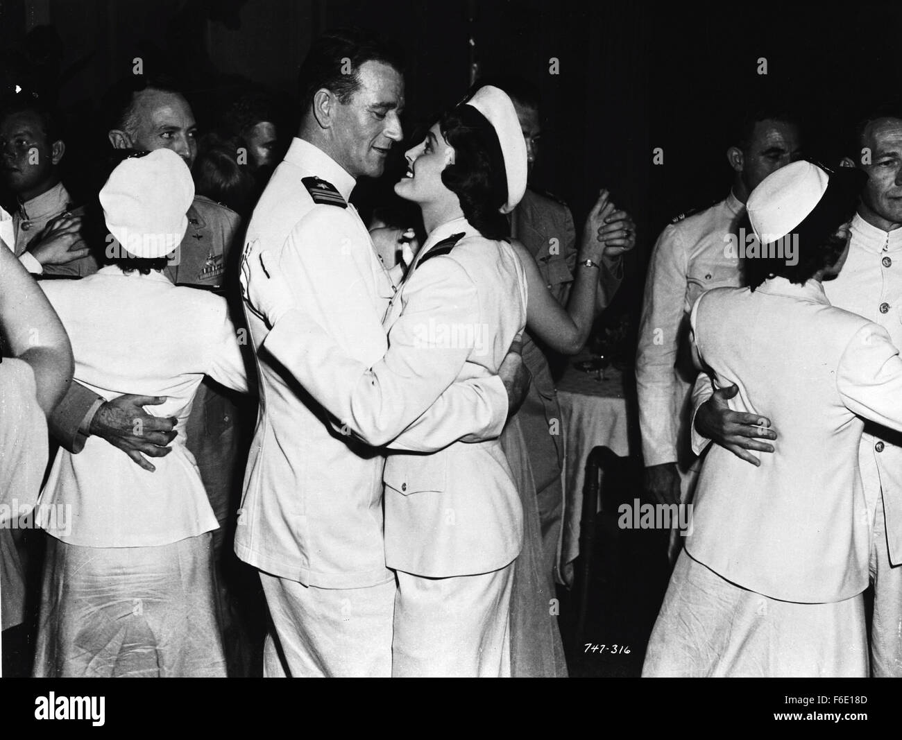 DATE DE SORTIE : Janvier 27, 1951. Titre du film : l'opération du Pacifique. STUDIO : Warner Bros Pictures. Résumé : PENDANT LA SECONDE GUERRE MONDIALE, Duke E. Gifford est commandant en second de l'USS Thunderfish, un sous-marin qui est le tir de torpilles qu'exploser trop tôt ou ne jamais exploser à tous. C'est un dilemme qu'il va éventuellement prendre personnellement. Encore plus personnelle est sa quête pour reconquérir son ex-femme, une infirmière ; mais il devra gagner son retour d'un aviateur de la marine qui se trouve être son petit frère du commandant. Photo : JOHN WAYNE le lieutenant Cmdr. Duke E. Gifford et PATRICIA NEAL Le Lieutenant Marie Stuart. Banque D'Images