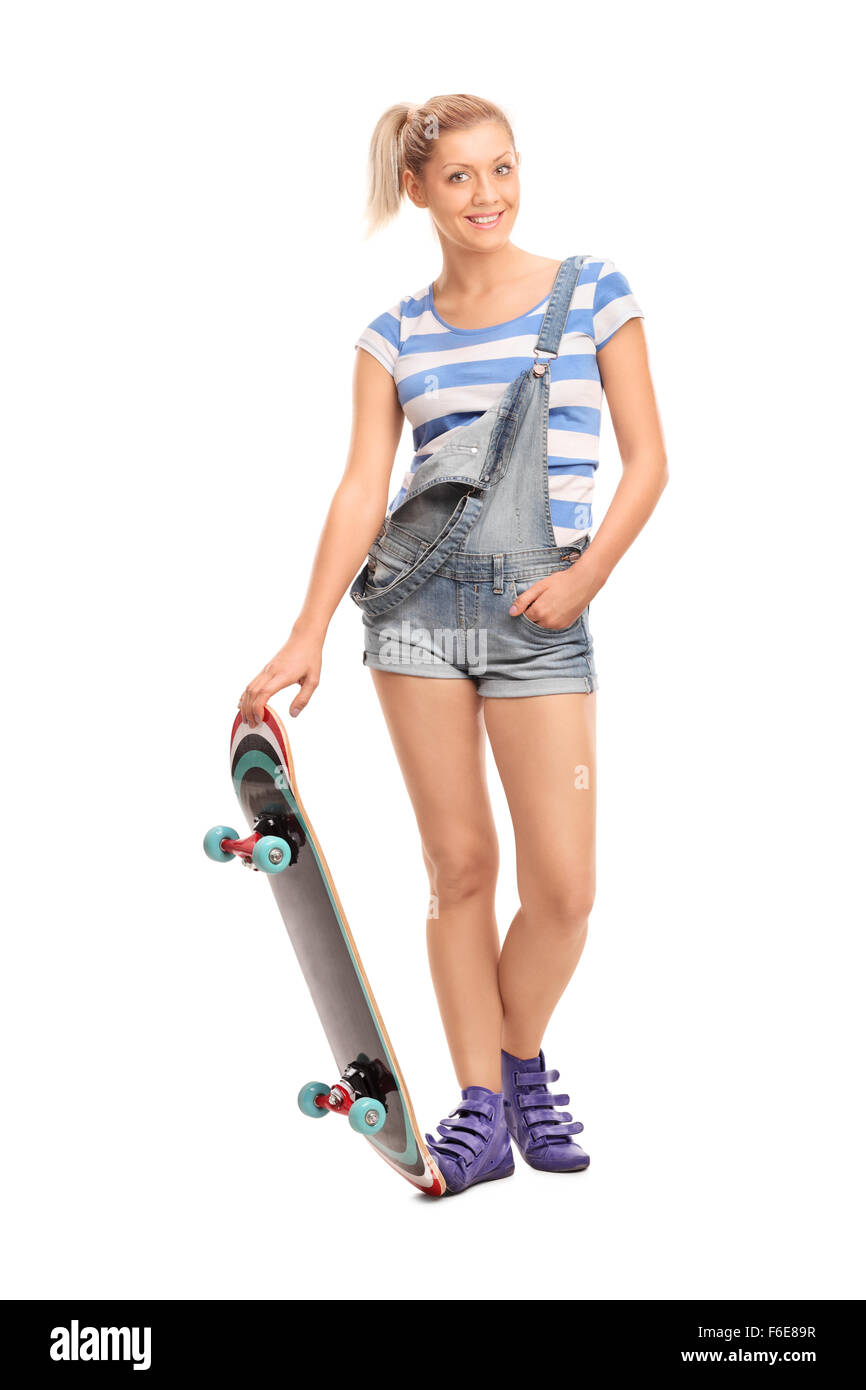 Portrait d'une jeune fille blonde hipster avec une planche à roulettes isolé sur fond blanc Banque D'Images