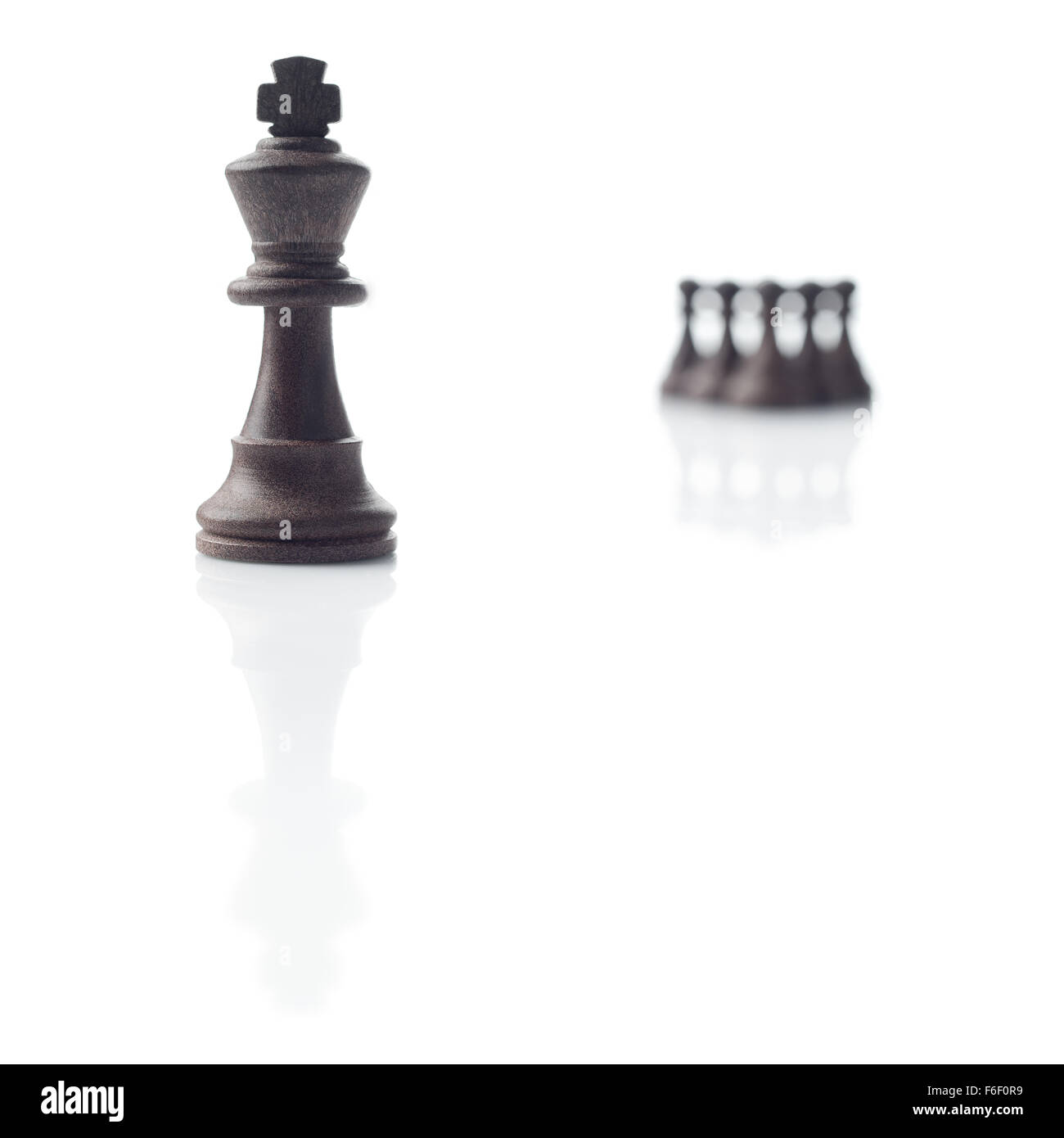 Les échecs. Roi noir, cinq pions hors foyer et leurs ombres sur fond blanc Banque D'Images