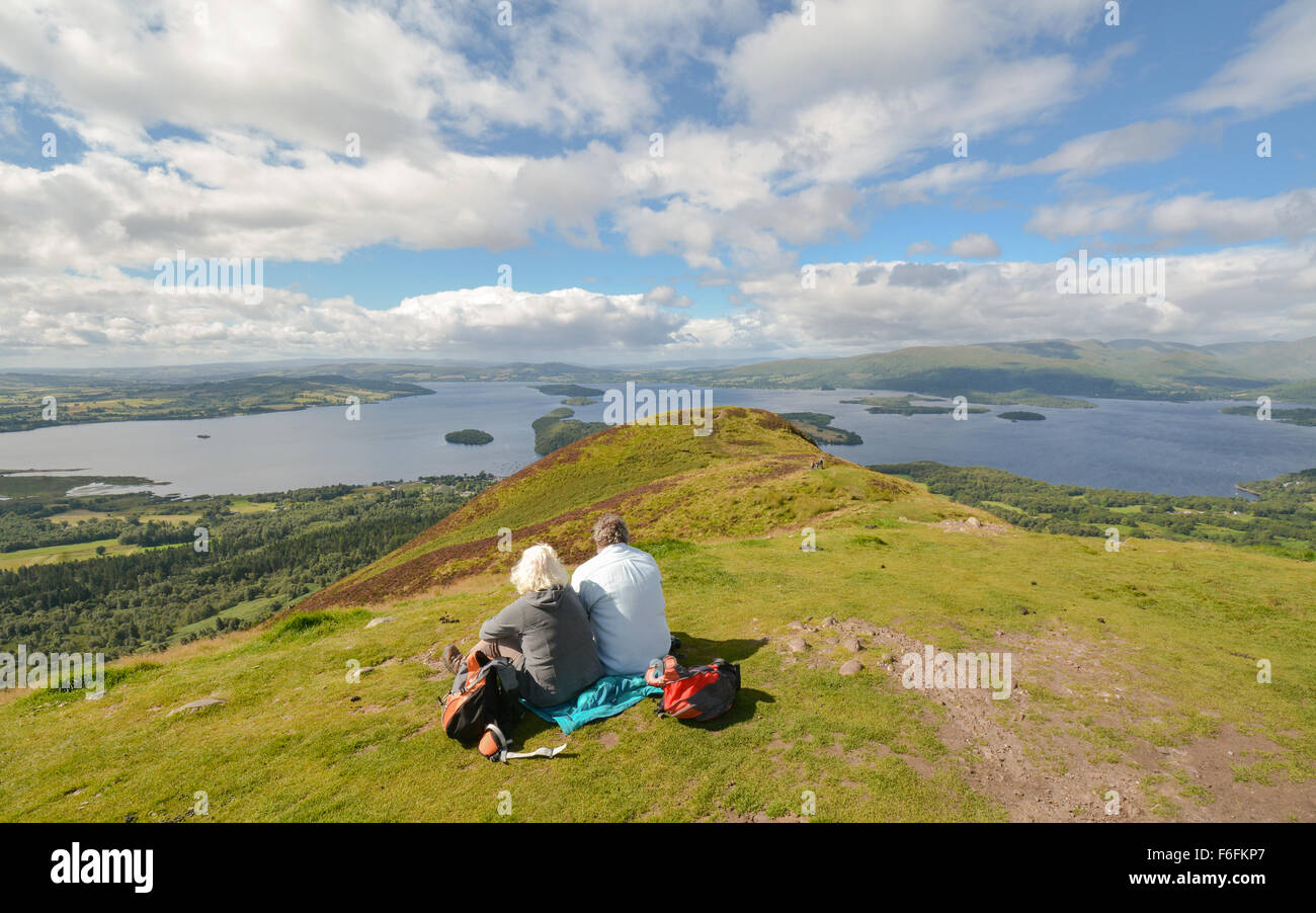 Deux marcheurs enjoying view du Loch Lomond - et géographique limite highland défaut ligne traversant il - à partir de la CONIC Hill Banque D'Images