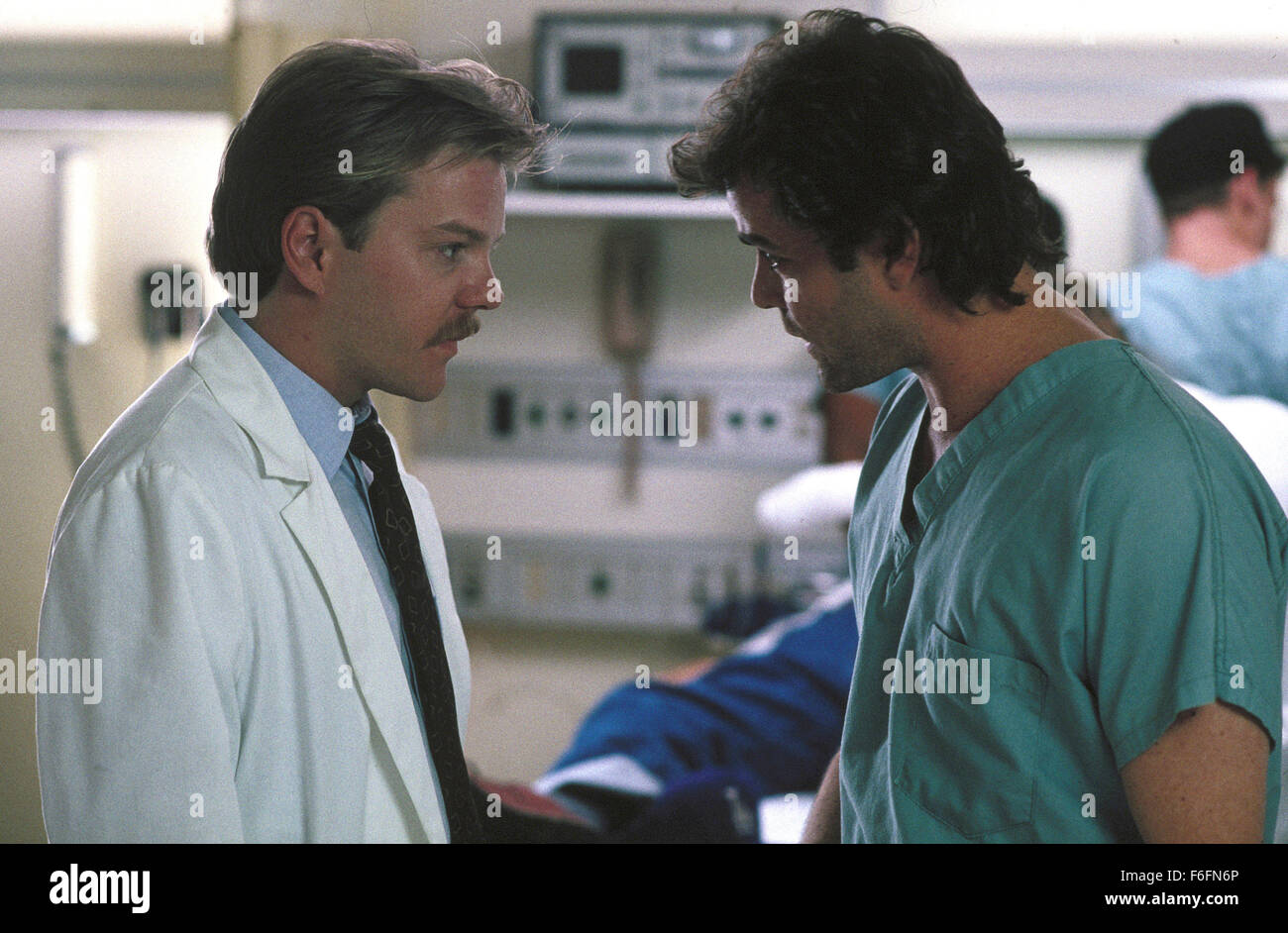 DATE DE SORTIE : Mars 13, 1992. Titre du film : l'article 99. STUDIO : Orion Pictures. Résumé : Un groupe de médecins dans un hôpital des anciens combattants doivent faire face à leur situation désespérée : trop de patients et pas assez de lits. La principale cause de leurs problèmes est de rigueur bureaucratique par les administrateurs de l'hôpital. Les médecins sont déterminés à donner le meilleur service qu'ils peuvent, même si cela signifie qu'en défiant les ordres de la direction et d'effectuer des opérations non autorisées. Sur la photo : Kiefer Sutherland comme le Dr Peter Morgan, Ray Liotta comme le Dr Richard Sturgess. Banque D'Images