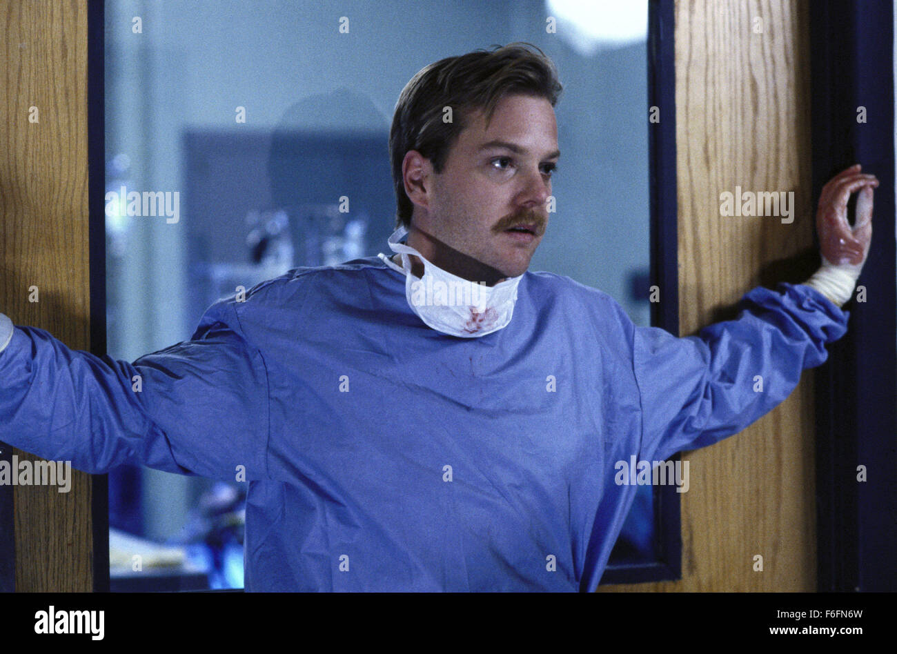 DATE DE SORTIE : Mars 13, 1992. Titre du film : l'article 99. STUDIO : Orion Pictures. Résumé : Un groupe de médecins dans un hôpital des anciens combattants doivent faire face à leur situation désespérée : trop de patients et pas assez de lits. La principale cause de leurs problèmes est de rigueur bureaucratique par les administrateurs de l'hôpital. Les médecins sont déterminés à donner le meilleur service qu'ils peuvent, même si cela signifie qu'en défiant les ordres de la direction et d'effectuer des opérations non autorisées. Sur la photo : Kiefer Sutherland comme le Dr Peter Morgan. Banque D'Images