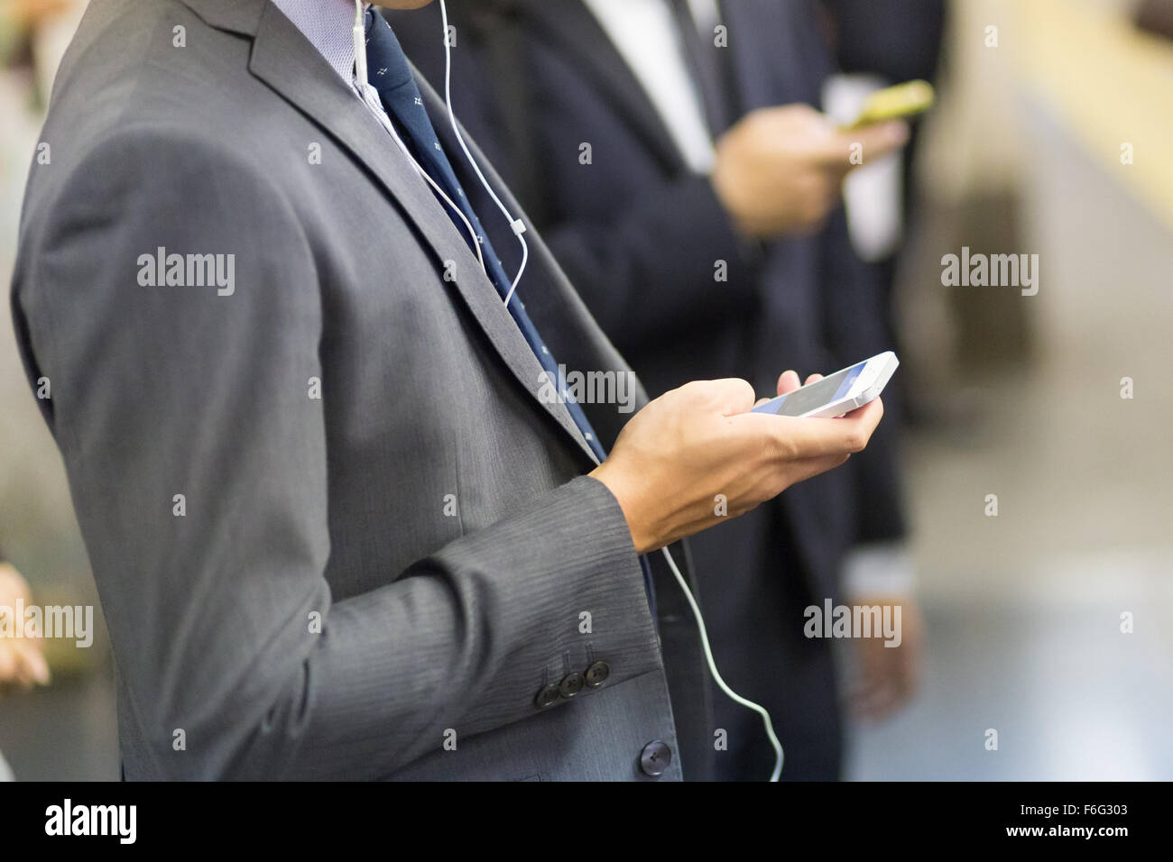 Hommes d'utiliser leurs téléphones cellulaires sur metro. Banque D'Images
