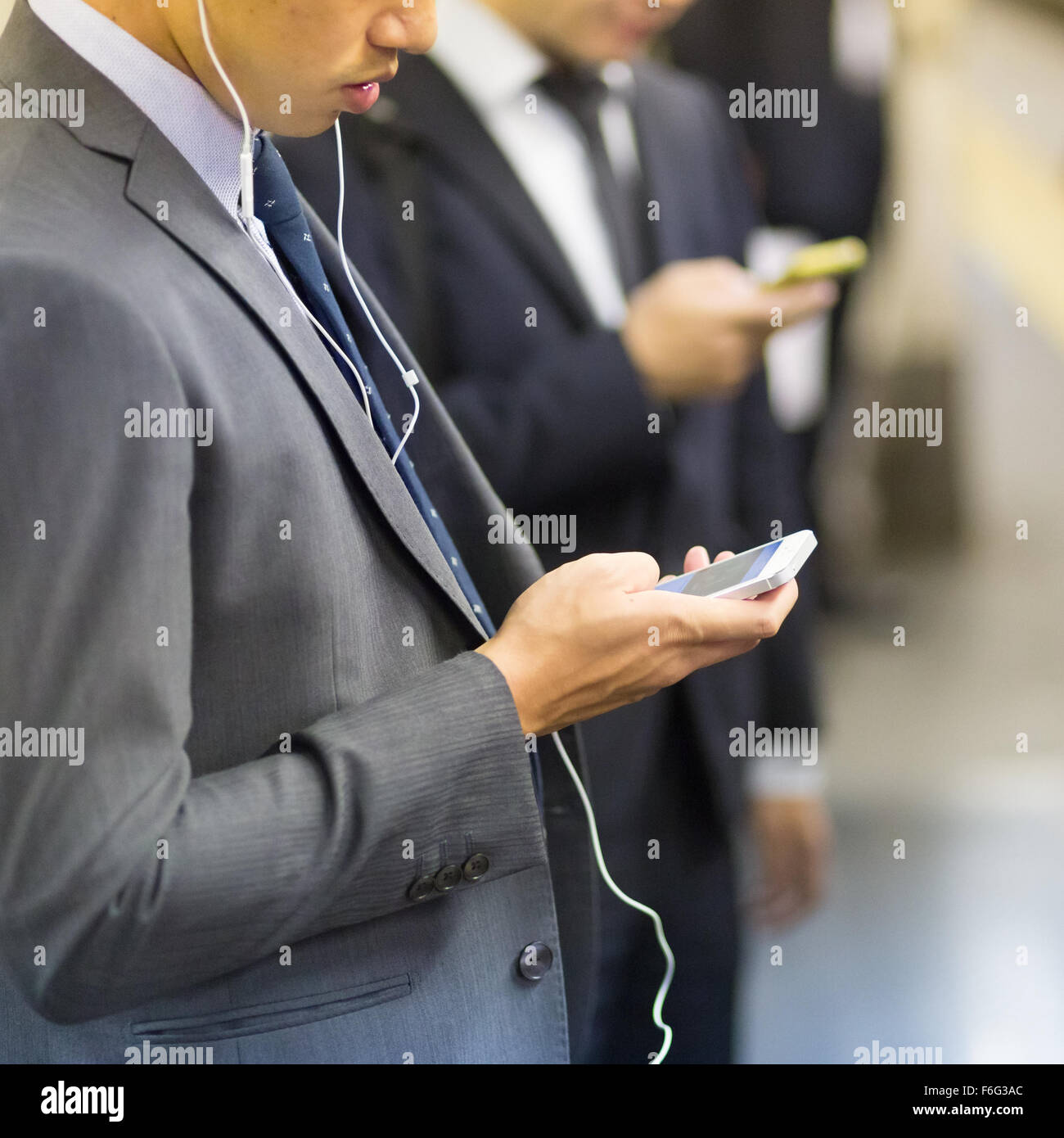 Hommes d'utiliser leurs téléphones cellulaires sur metro. Banque D'Images