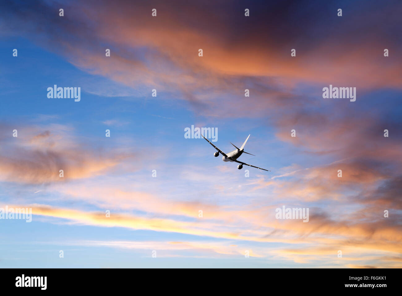 Vol d'un avion au coucher de soleil nuages Banque D'Images