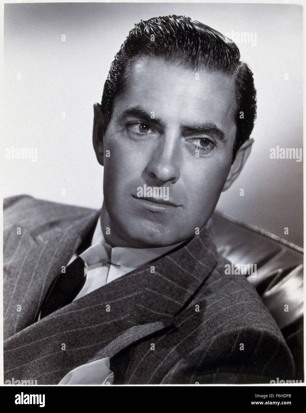 1946, le titre du film : RAZOR'S EDGE, Directeur : EDMUND GOULDING, Studio : FOX, Photo : HEAD SHOT, TYRONE POWER, cheveux - MARÉE NOIRE, costume, homme, robuste, à l'écart, portrait, studio, assis, DE LA TABLE, se prélasser, FRAIS, sophistiqué, arrogant. (Crédit Image : SNAP) Banque D'Images